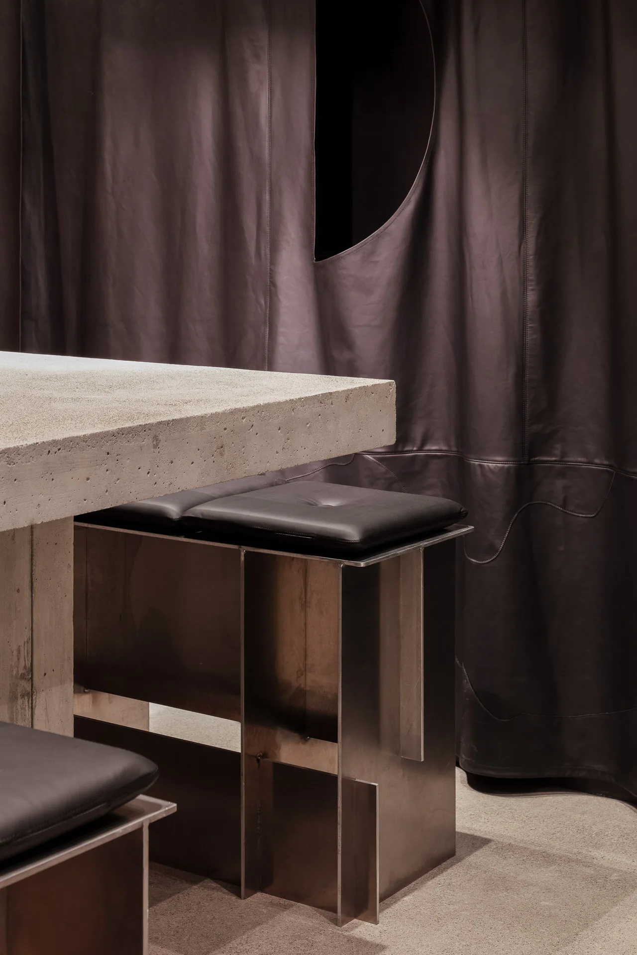 Hocker aus Aluminium mit schwarzer Lederauflage ergänzen das Mobiliar.