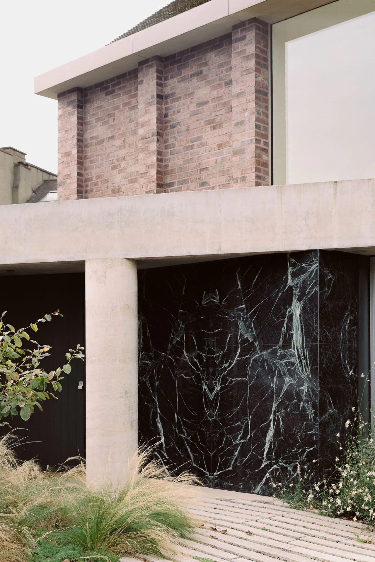 Ein dunkelgrünes Wandstück aus Marmor zitiert Mies van der Rohes Barcelona-Pavillon.