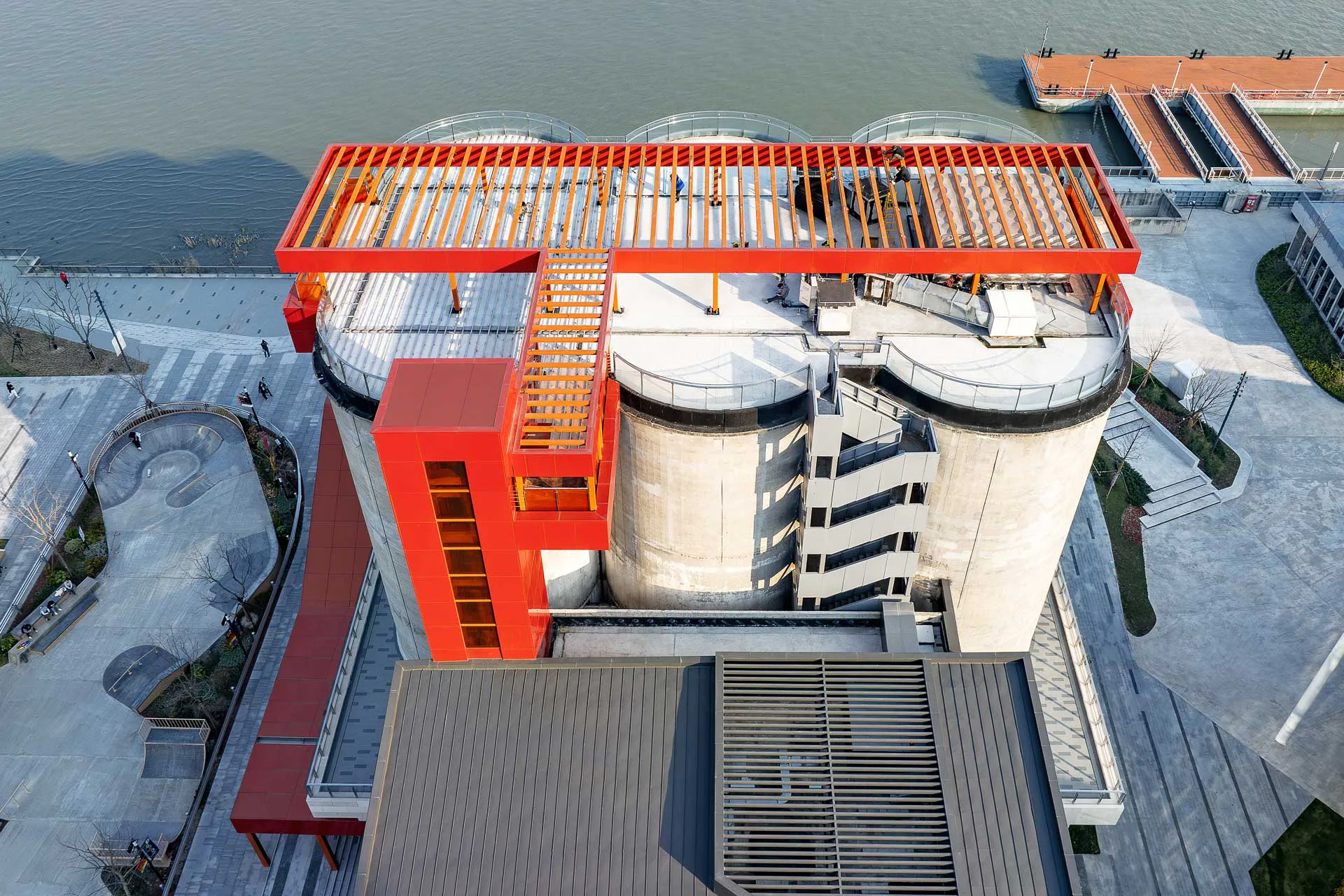 An den ehemaligen Industriebauten sind die neuen Erschließungsbereiche und Dachterrassen durchgehend in Orangerot gehalten.