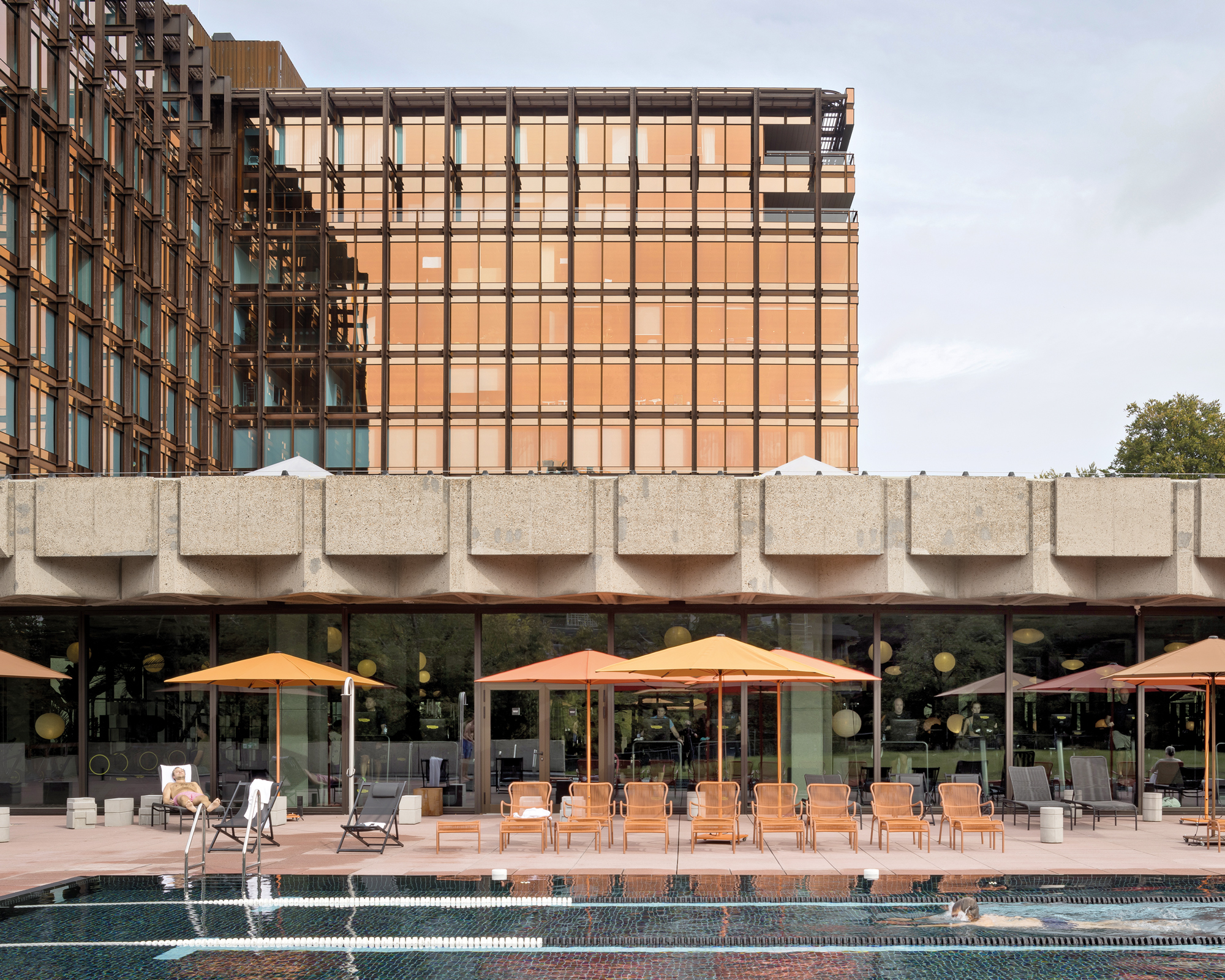 The complex is surrounded by generous terraces arranged at different levels. The area featuring the outdoor pool is connected to the low-rise structure now used as a fitness studio.