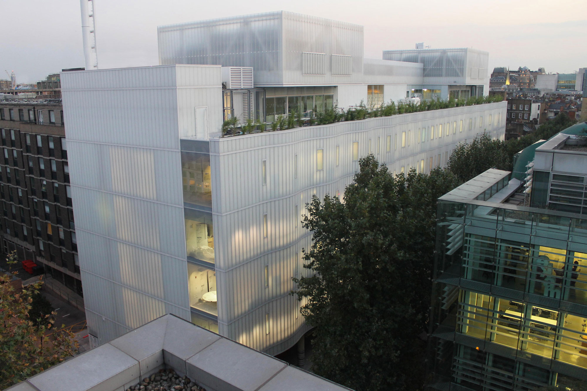 Das 2016 eröffnete Sainsbury Wellcome Centre des UCL vereint Neurowissenschaftler zur Erforschung von Gehirnschaltkreisen. Der preisgekrönte, siebenstöckige Bau von Ian Ritchie Architects umfasst hochmoderne Labors, kostete rund 90 Mio. Euro und bietet 14 000 m² Fläche. Prägend ist die geschwungene, transluzente LINIT EcoGlass-Fassade, die Energie spart, diffuses Licht liefert und abends weiß leuchtet. Das Gebäude erhielt die BREEAM-Bewertung „ausgezeichnet“.