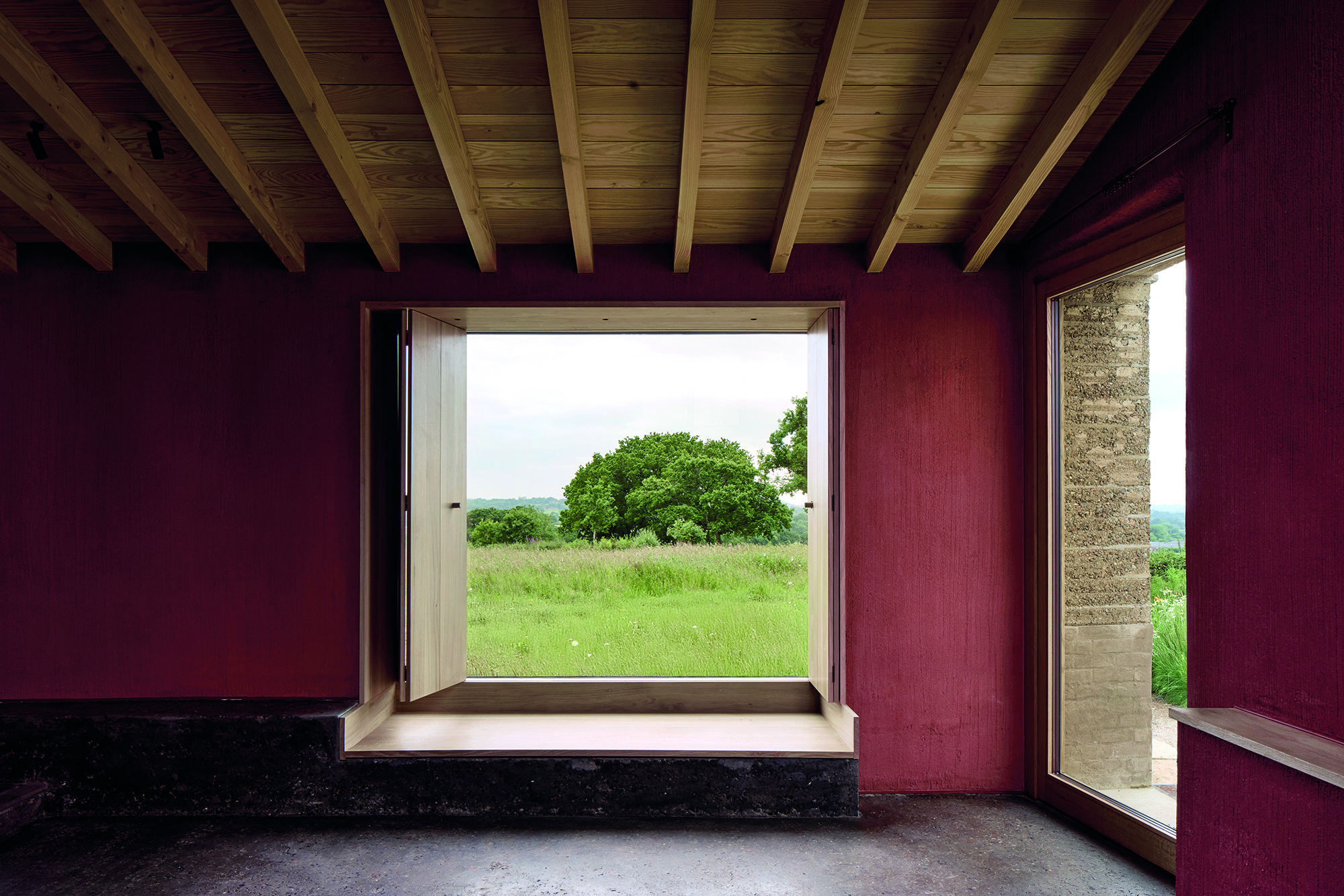 Das Wohnhaus ist in verschiedene Bau­körper gegliedert. Während die Diele ­einen Blick in das Obergeschoss gewährt, hat man im Wohnzimmer Aussicht auf die freie Landschaft.