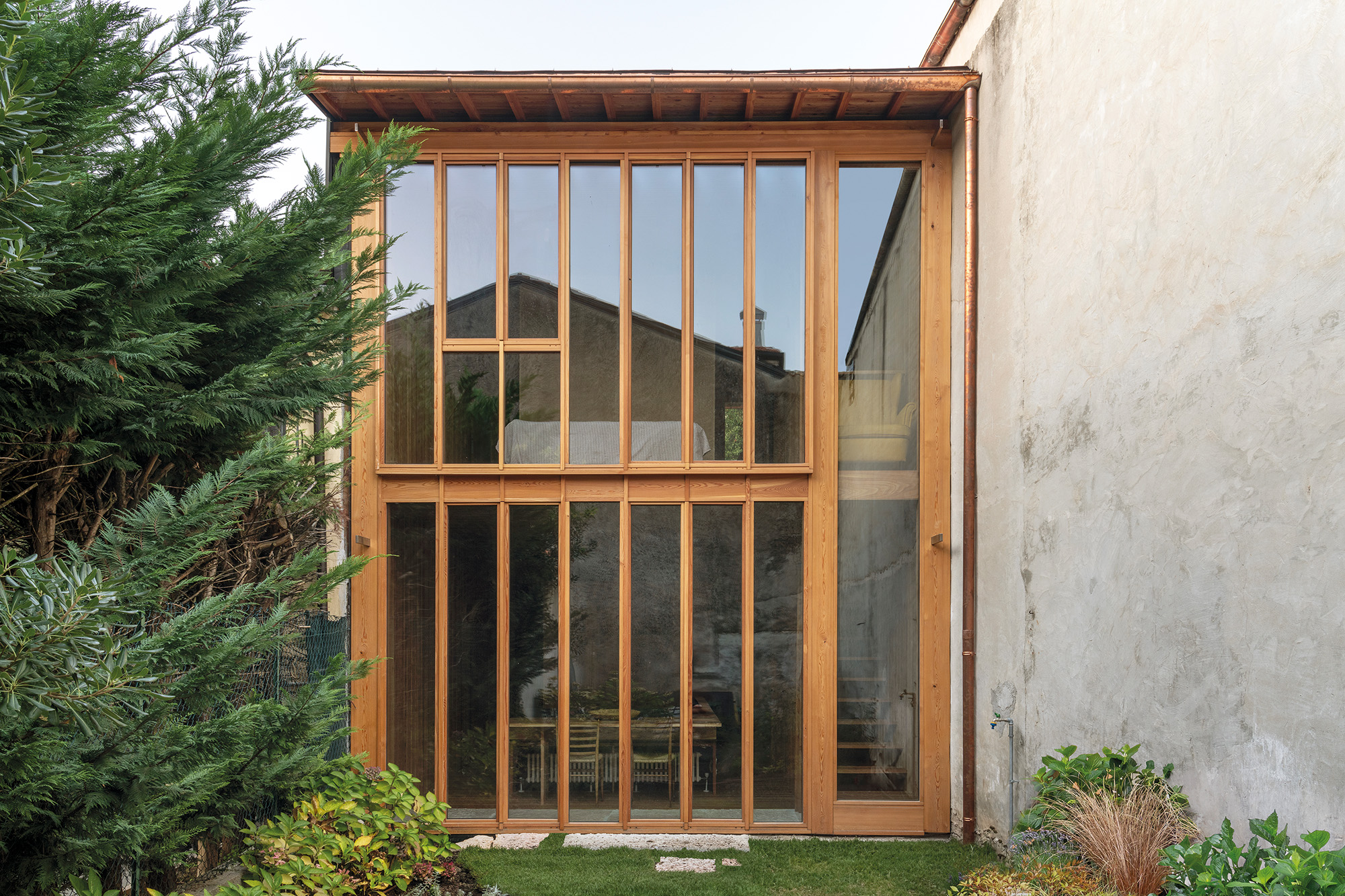 If the residents aren’t at home, a natural stone slab serves to hermetically seal off the recessed vestibule.