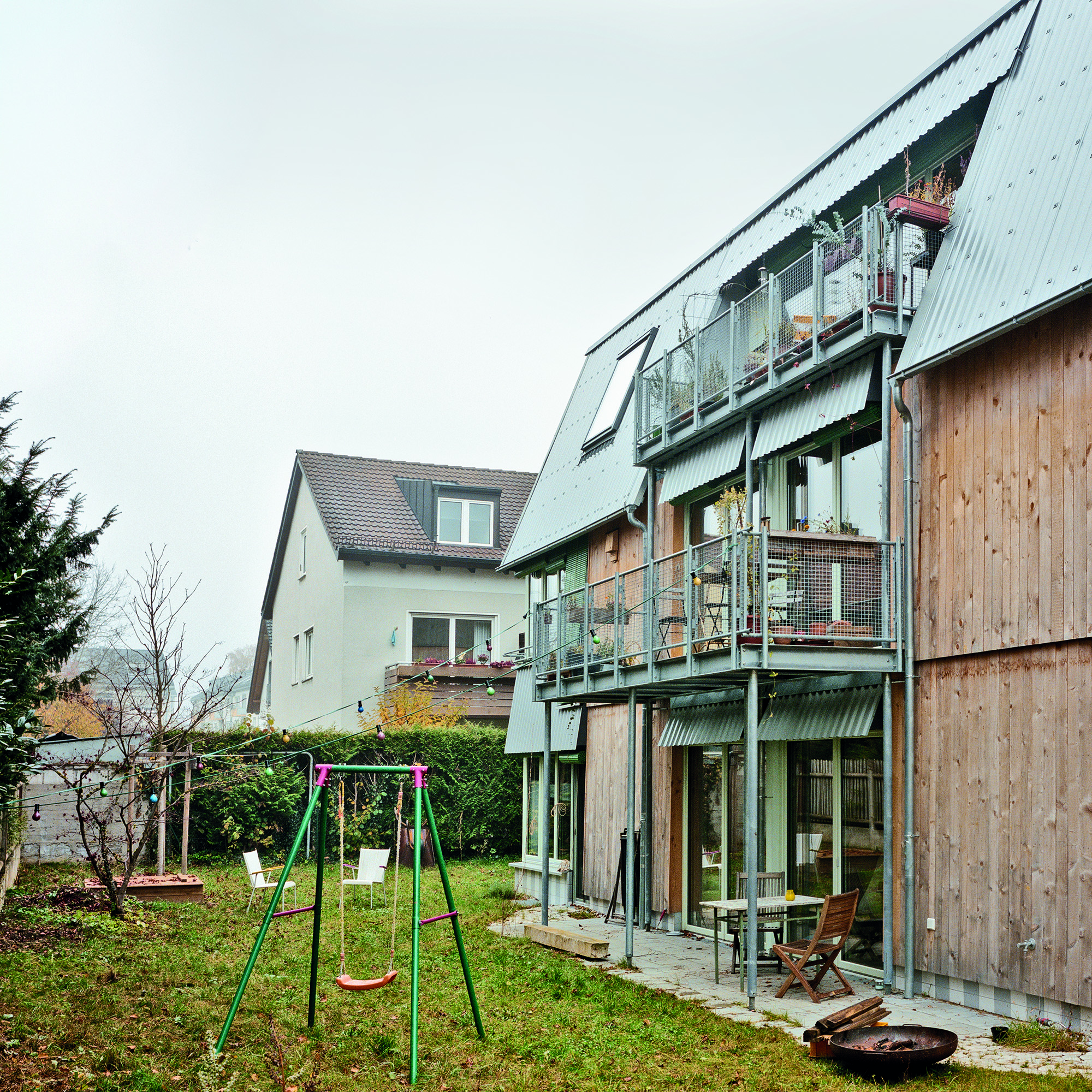 Zur Straße zeigt sich das Gebäude dreigeschossig. Zum Garten schließt ein Mansarddach die zweigeschossige Fassade ab.