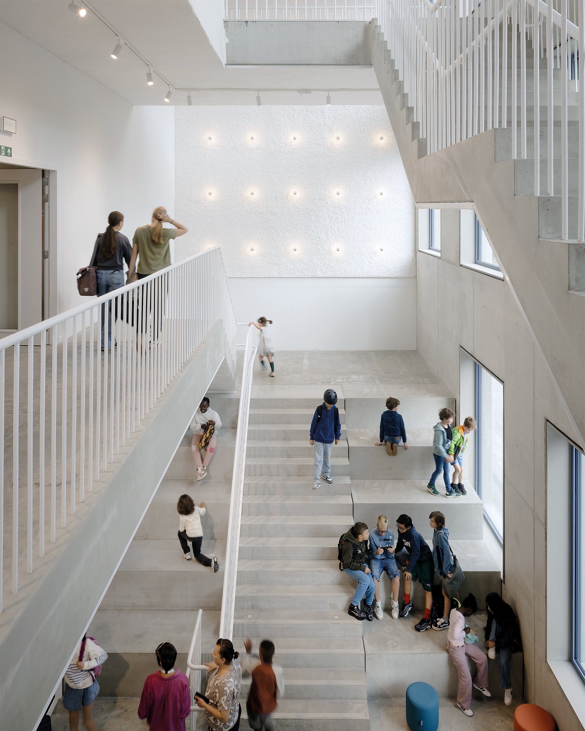Sitzstufen verwandeln das lichte Haupttreppenhaus in einen attraktiven Aufenthaltsort.