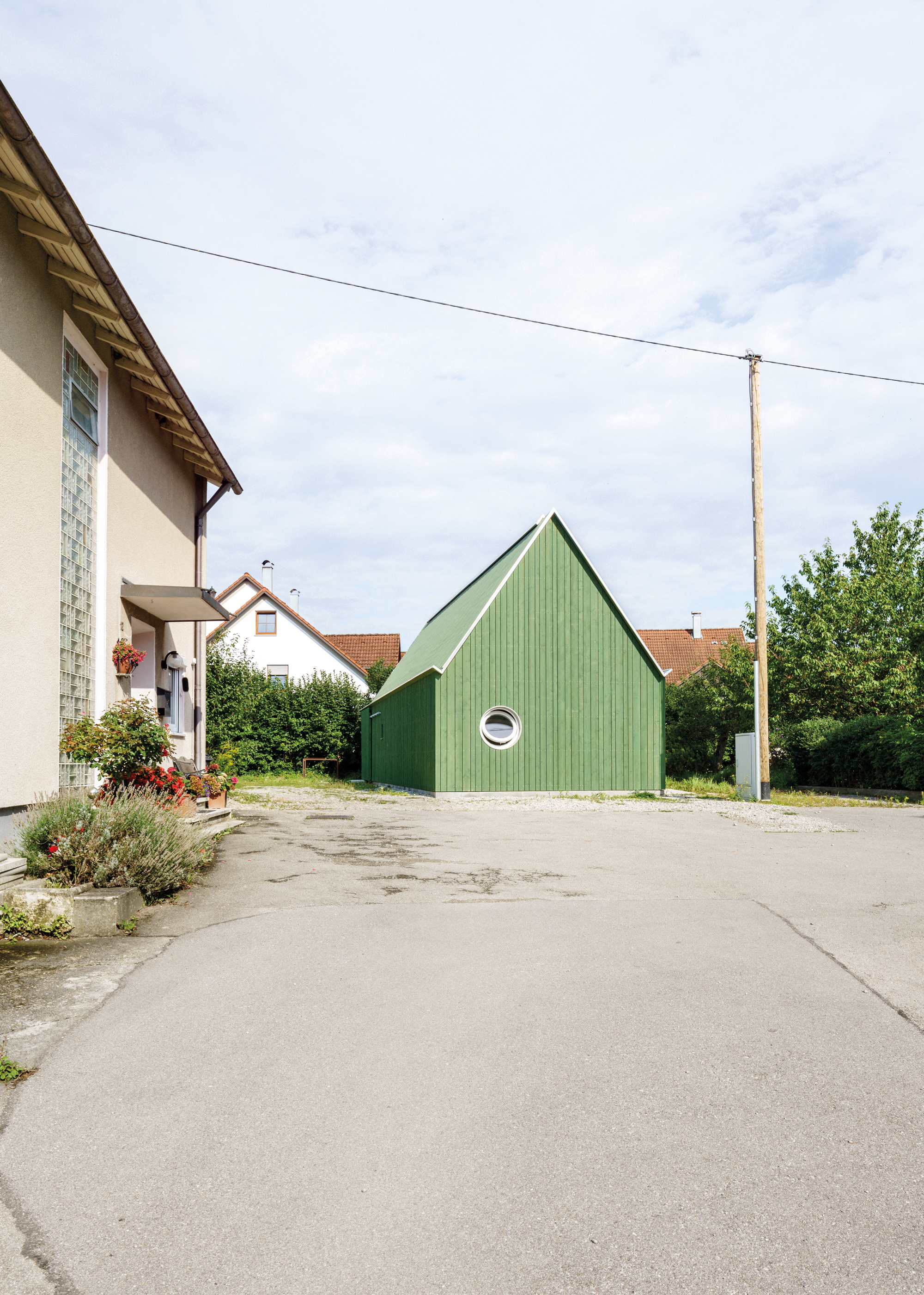 Außenansicht des Ateliers mit vertikaler grüner Holzschalung.