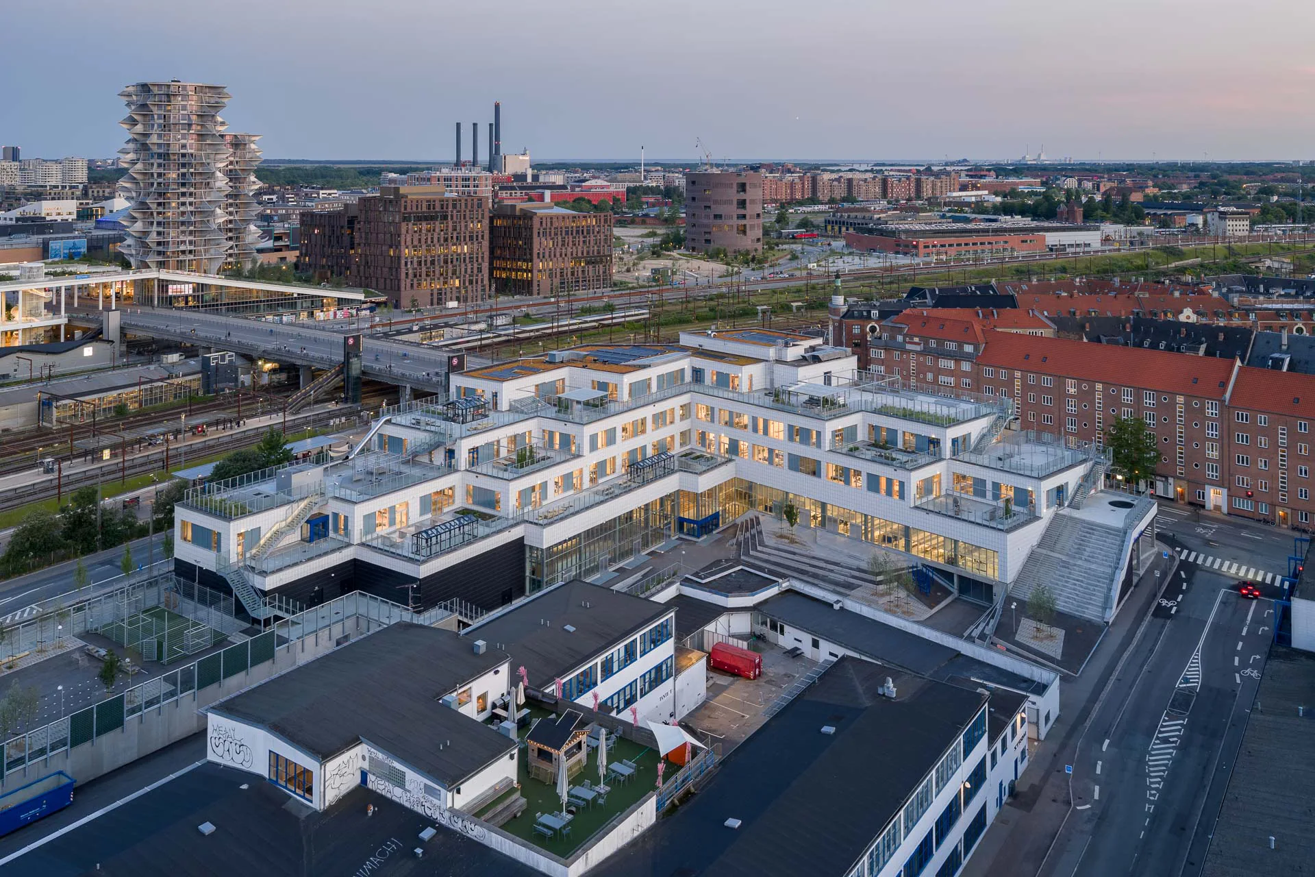 An der Straßenecke im Süden steigt die Gebäudehöhe der Schule bis auf fünf Geschosse an. Drei der Dachebenen stehen für die Schüler als Pausenhof zur Verfügung.