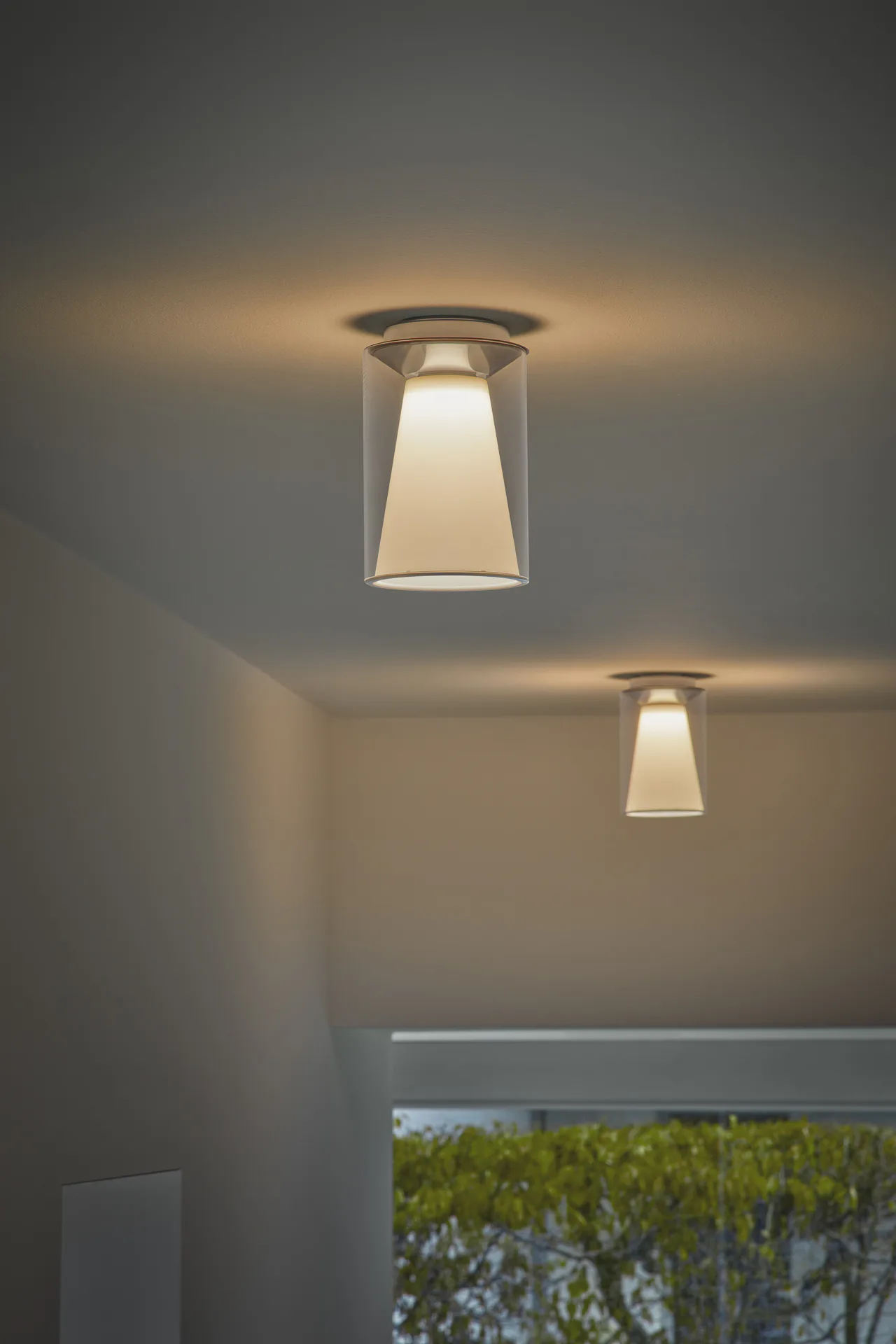 Curling als flacher Zylinder, Draft mit abgeflachter Glaskugel und Innenreflektor, Drum mit transparentem Mantel und opalem Kegel. Der konstruktive Aufbau hält die Leuchten formal ruhig.