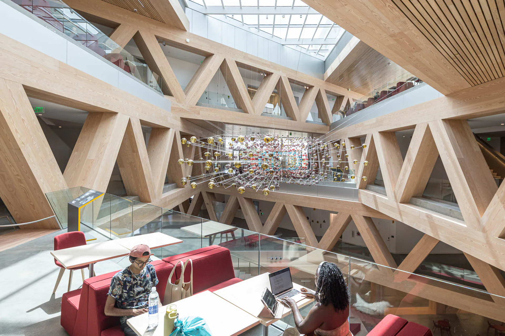 Holzverkleidete Fachwerkträger aus Stahl machen das komplexe Tragwerk des Gebäudes im Atrium ablesbar.