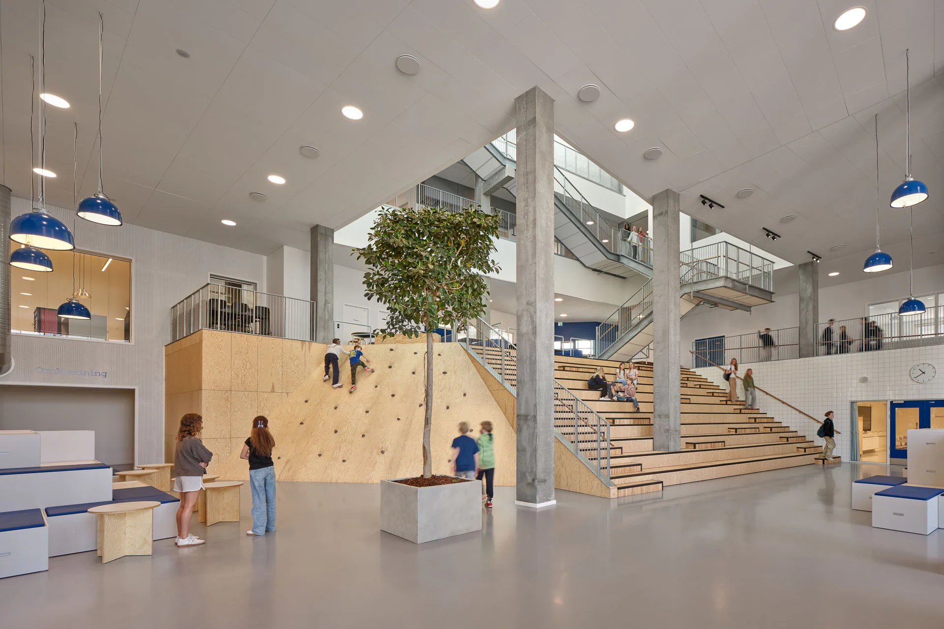 Aus dem Atrium an der Schnittstelle der beiden Gebäudeflügel führen abwechslungsreiche Treppenläufe in die oberen Geschosse.