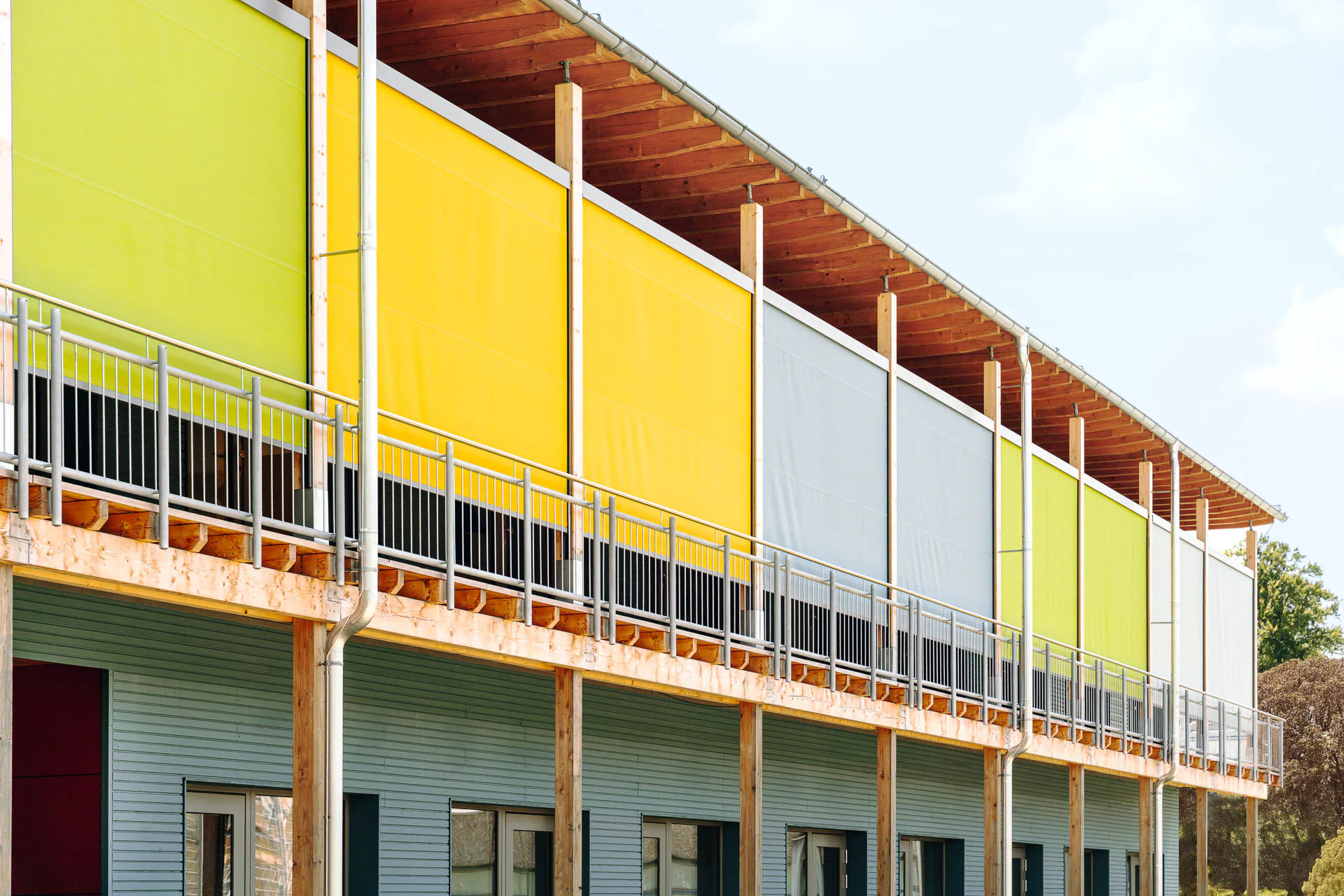 Der außenliegende textile Sonnenschutz wird zur zweiten, bewusst vielfarbig gestalteten Schicht.