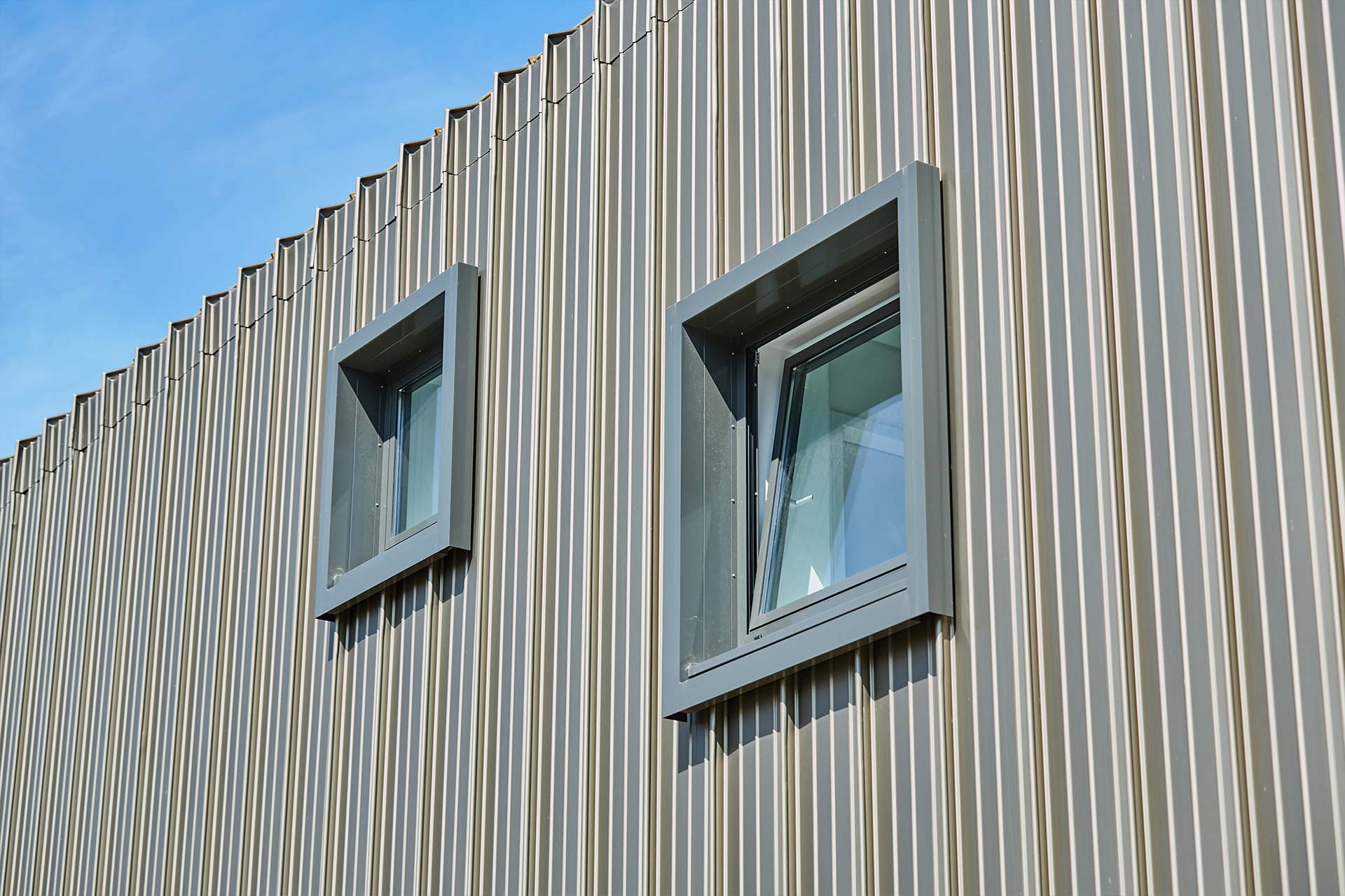 Je nach Blickwinkel und Lichteinfall nimmt die Fassade einen dunklen Bronze- oder einen hellen Goldton an.