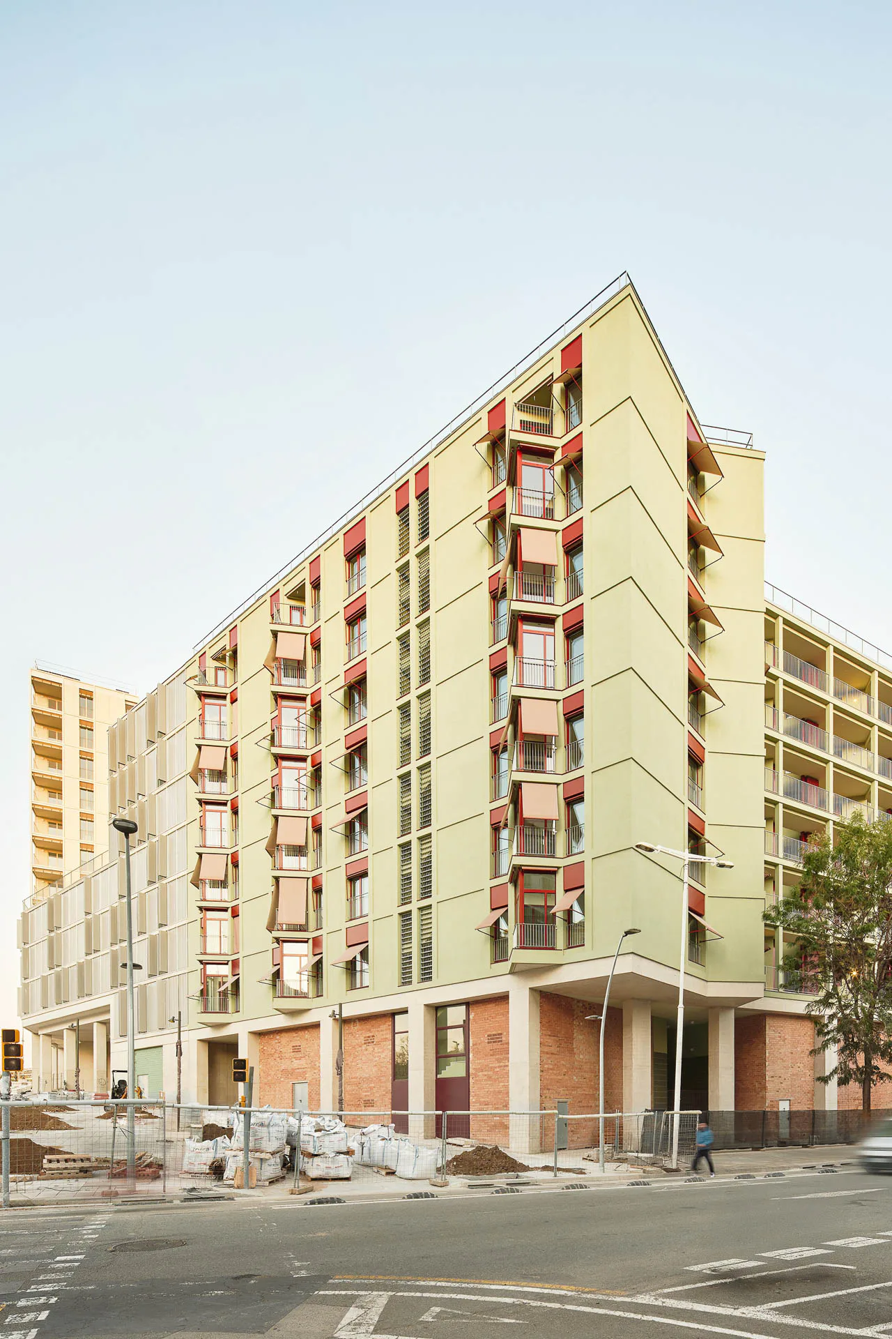 Über dem hohen Gebäudesockel aus Beton und Ziegeln erheben sich sieben farbenfroh gestaltete Wohngeschosse.