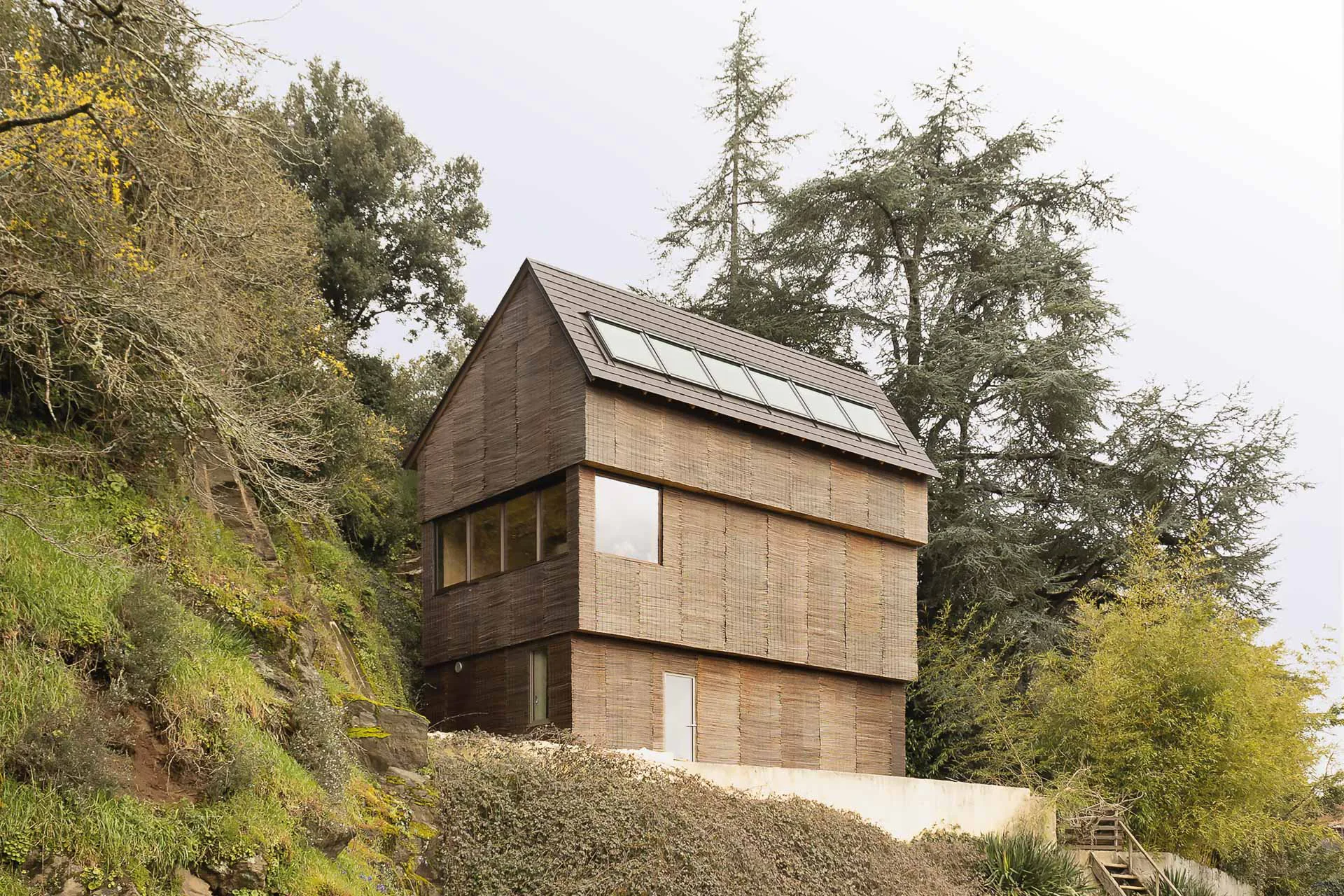 Inmitten wilder Natur schmiegt sich das kleine Wohnhaus an eine Felswand.