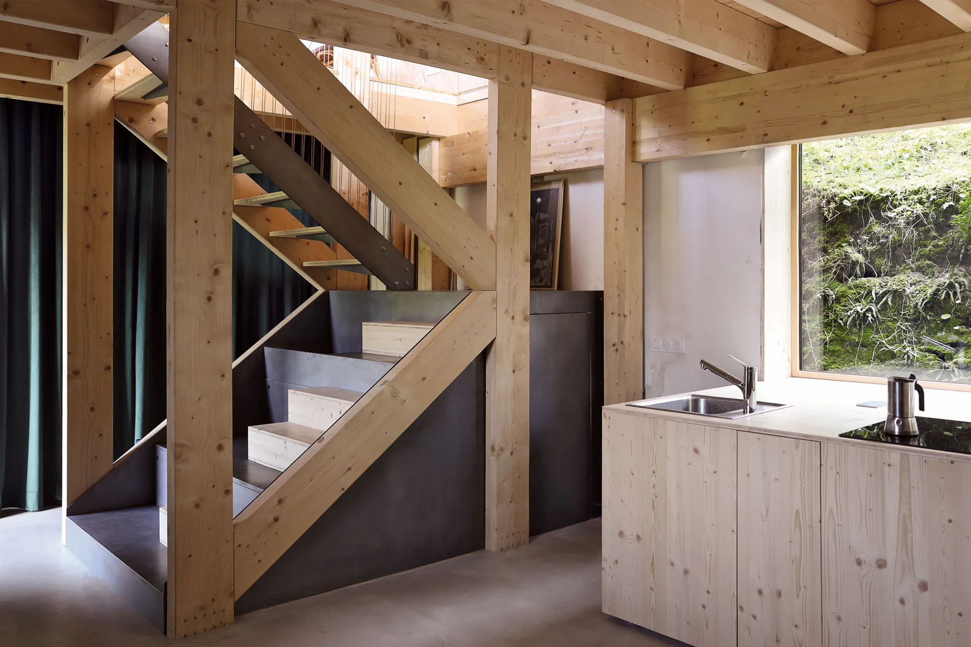 Die Treppenstruktur im Zentrum steift das Wohnhaus aus und bietet Stauraum für die Küche.
