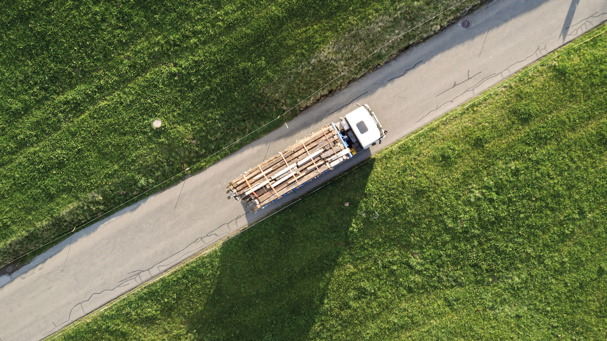 Ein Lkw bringt die nummerierten Balken auf das 700 Meter entfernte Grundstück. Dort wird das Gässlihus über einem neu errichteten Natursteinsockel wieder aufgebaut.