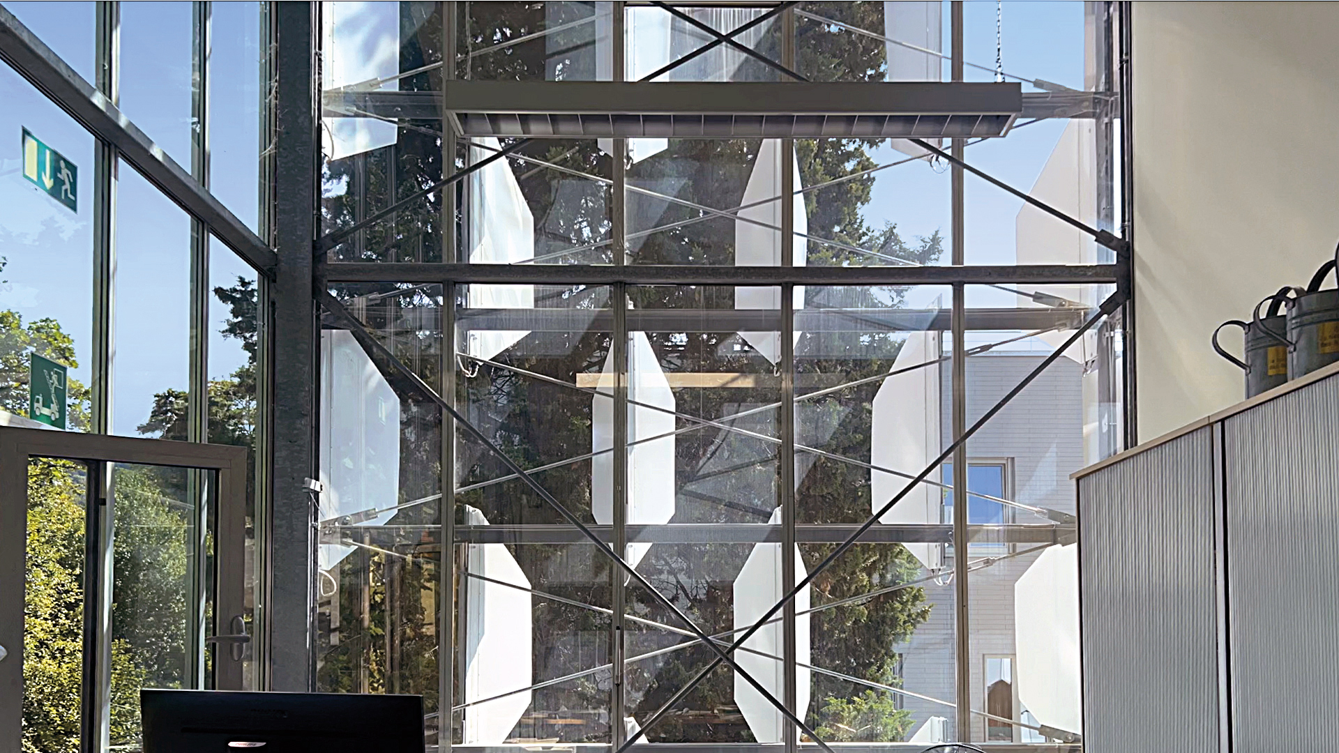 In geöffnetem Zustand erlauben die Fassadenelemente den fast ungehinderten Blick ins Freie. Teils sind sie mit Photovoltaikmodulen zur Energiegewinnung bestückt.