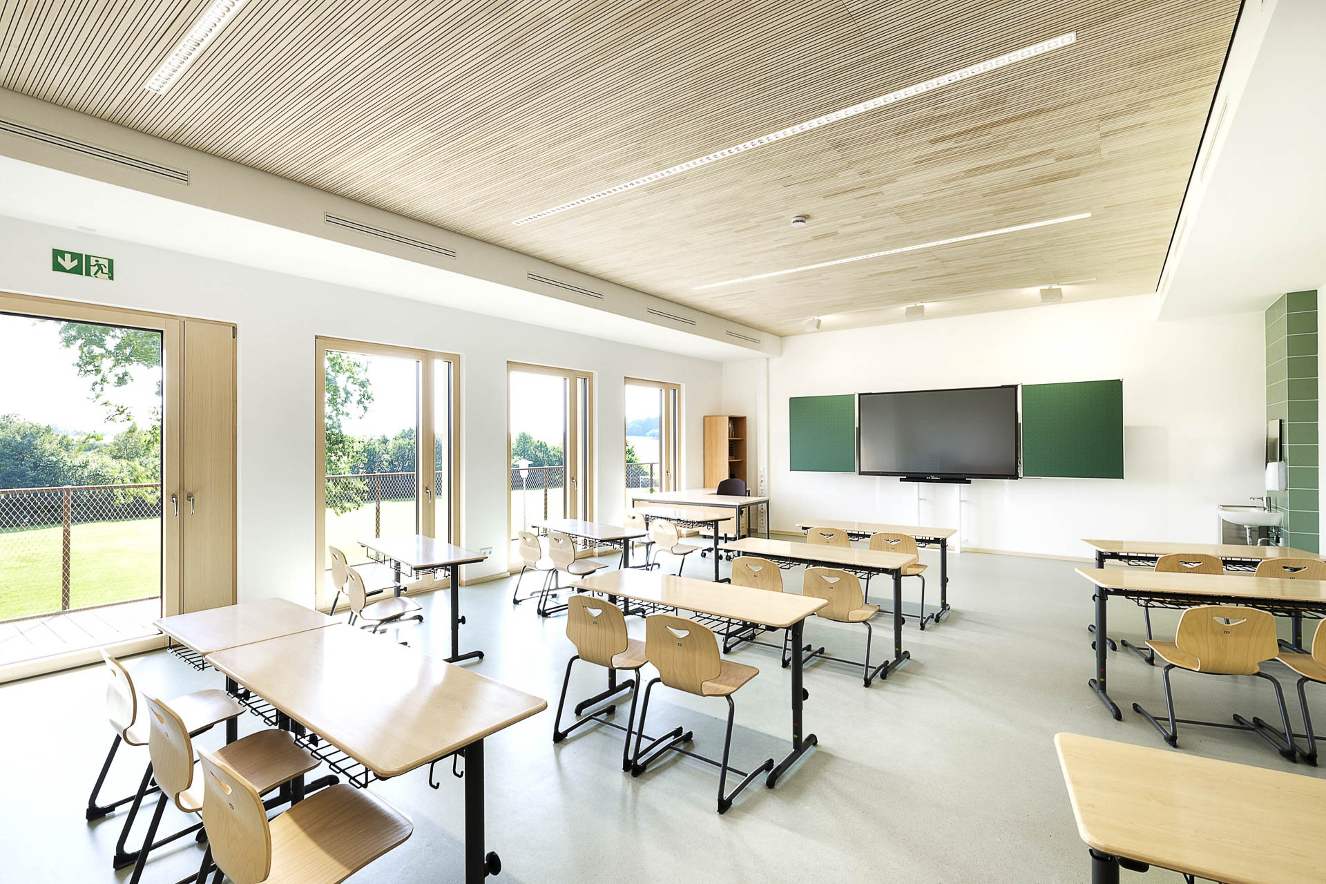 Zweigeschossige Aula im Erweiterungsbau der Dominik-Brunner-Schule in Ergolsbach – Bindhammer Architekten gliederten den Neubau in Unterrichts-, Aufenthalts- und Pausenbereiche mit hohen akustischen Anforderungen.