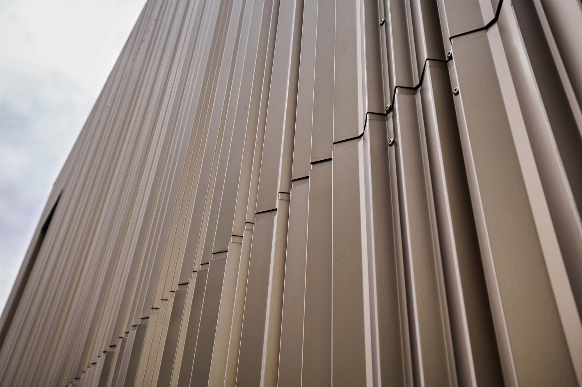 Der Farbton Bronze B40 unterstreicht die gefaltete Fassade besonders bei Lichteinfall.