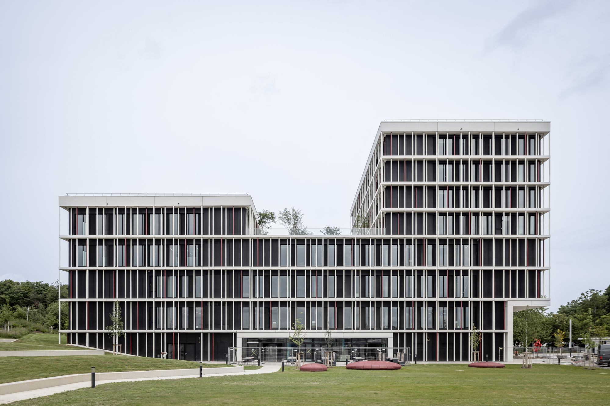 Keramische Stäbe, die wie schwebende Akzente vor der Glasfront angebracht sind, wirken wie ein filigranes Kartenhaus, das dem Medizin-Campus der Universität in Augsburg eine Seele verleiht.