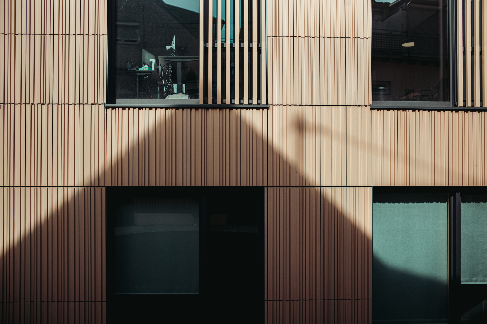 Light and shadow define the ceramic surface’s varied structure, bringing the facade’s dynamic design to life.
