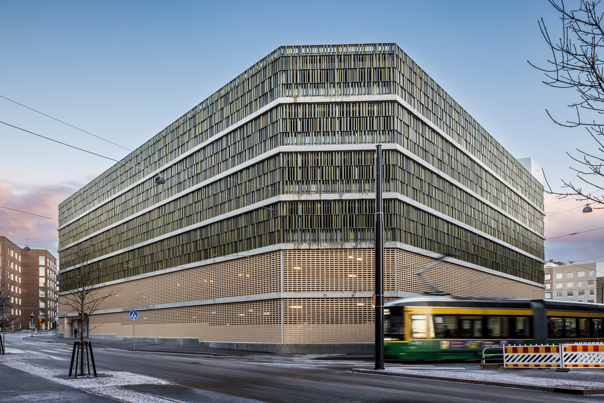 Drei unterschiedlich große Tubes in harmonisch aufeinander abgestimmten Grüntönen verleihen der klar gegliederten Architektur des Melkinlaituri Parkhauses in Finnland eine natürliche Tiefe, organische Lebendigkeit und eine vielschichtige, lebendige Fassadenstruktur.