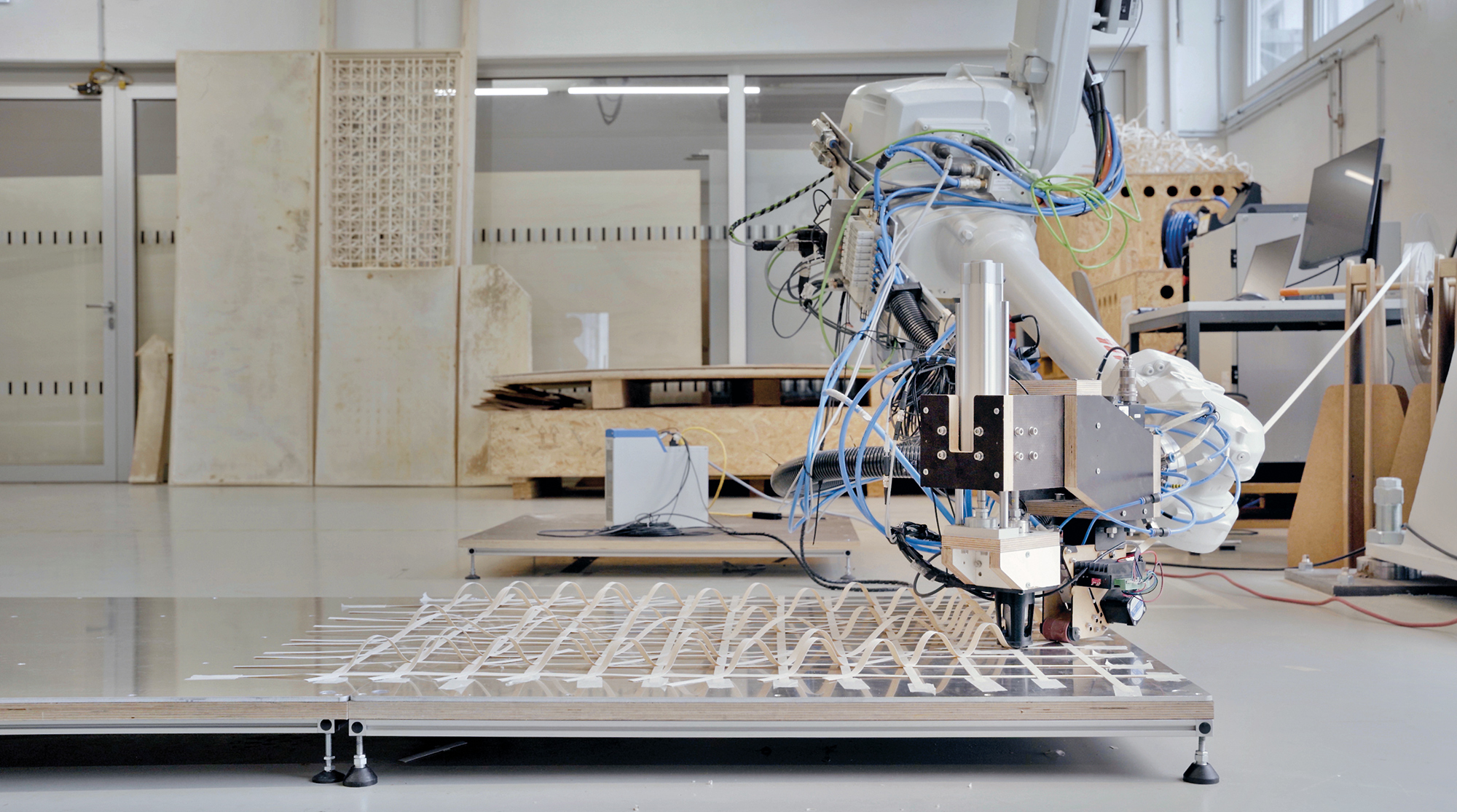 Die Bewehrung der Trennwände besteht aus robotisch hergestellten Furniergittern. Darauf wird schichtweise das Myzelium aufgetragen.