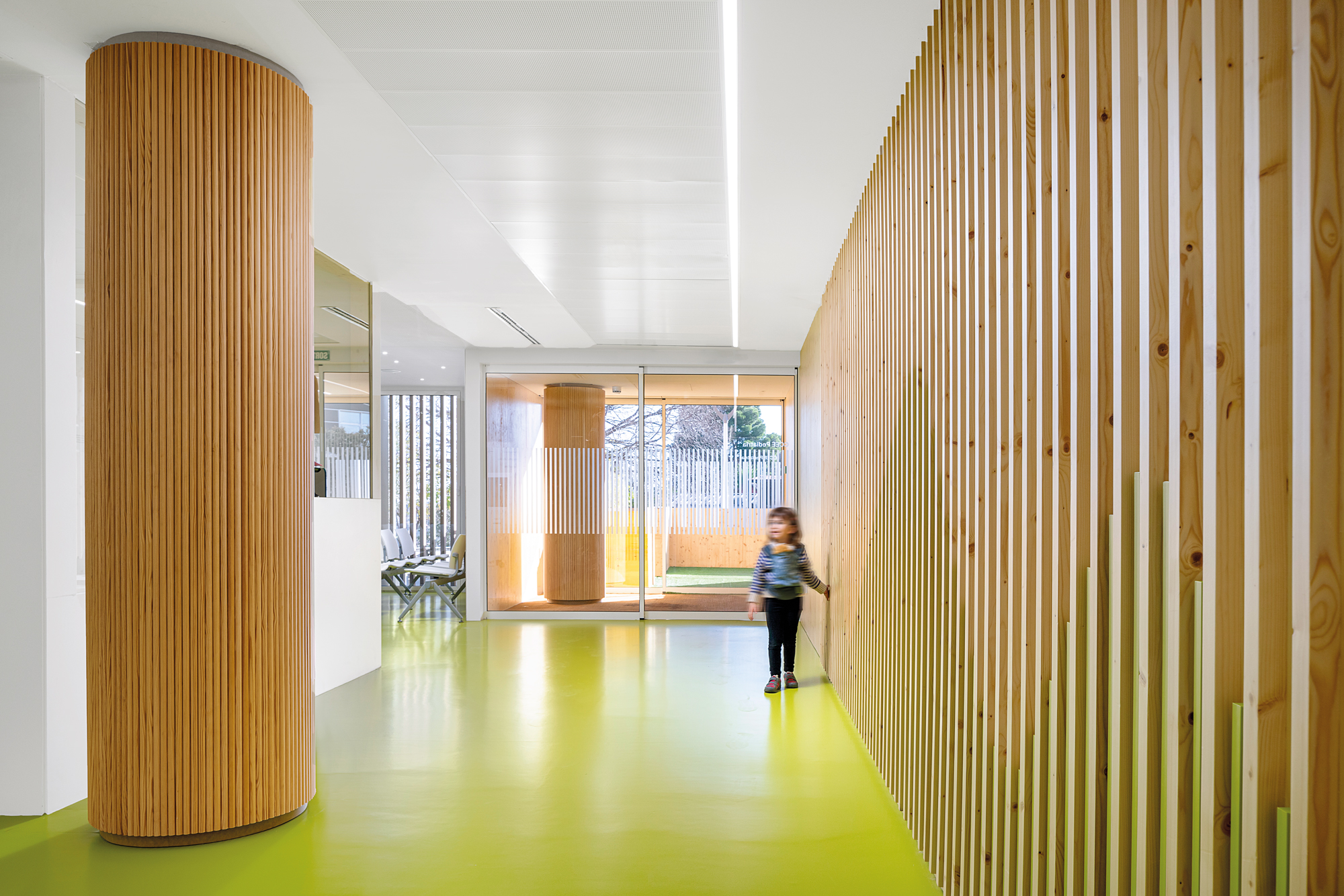 The motif of the ­vertical slats is recalled in the interiors. Flooring materials in different colours ­provide orientation and define the inte­rior design together with the wood elements.