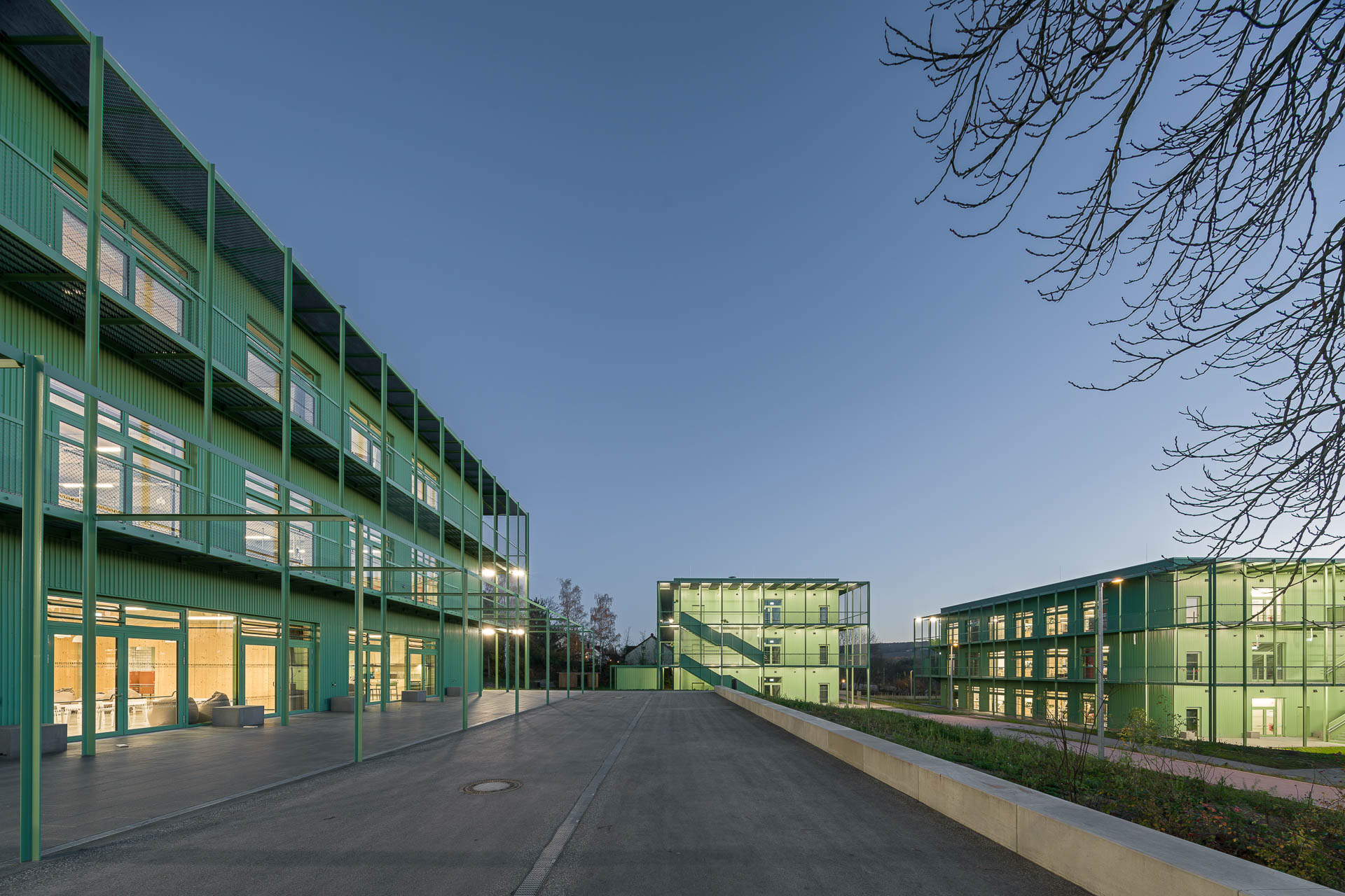 Auf dem leicht abschüssigen Grundstück am Stadtrand von Weimar ergänzen drei je dreigeschossige Baukörper die bestehende Sporthalle.