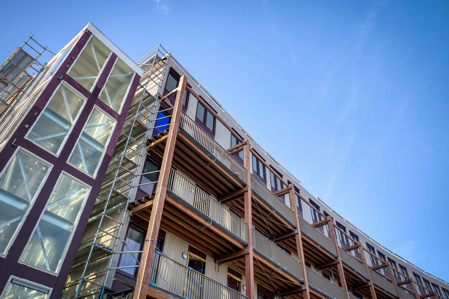 Die Holzmodule bilden tragende Strukturen und umlaufende Laubengänge für die 103 Wohneinheiten, darunter soziale sowie frei finanzierte Mietwohnungen.
