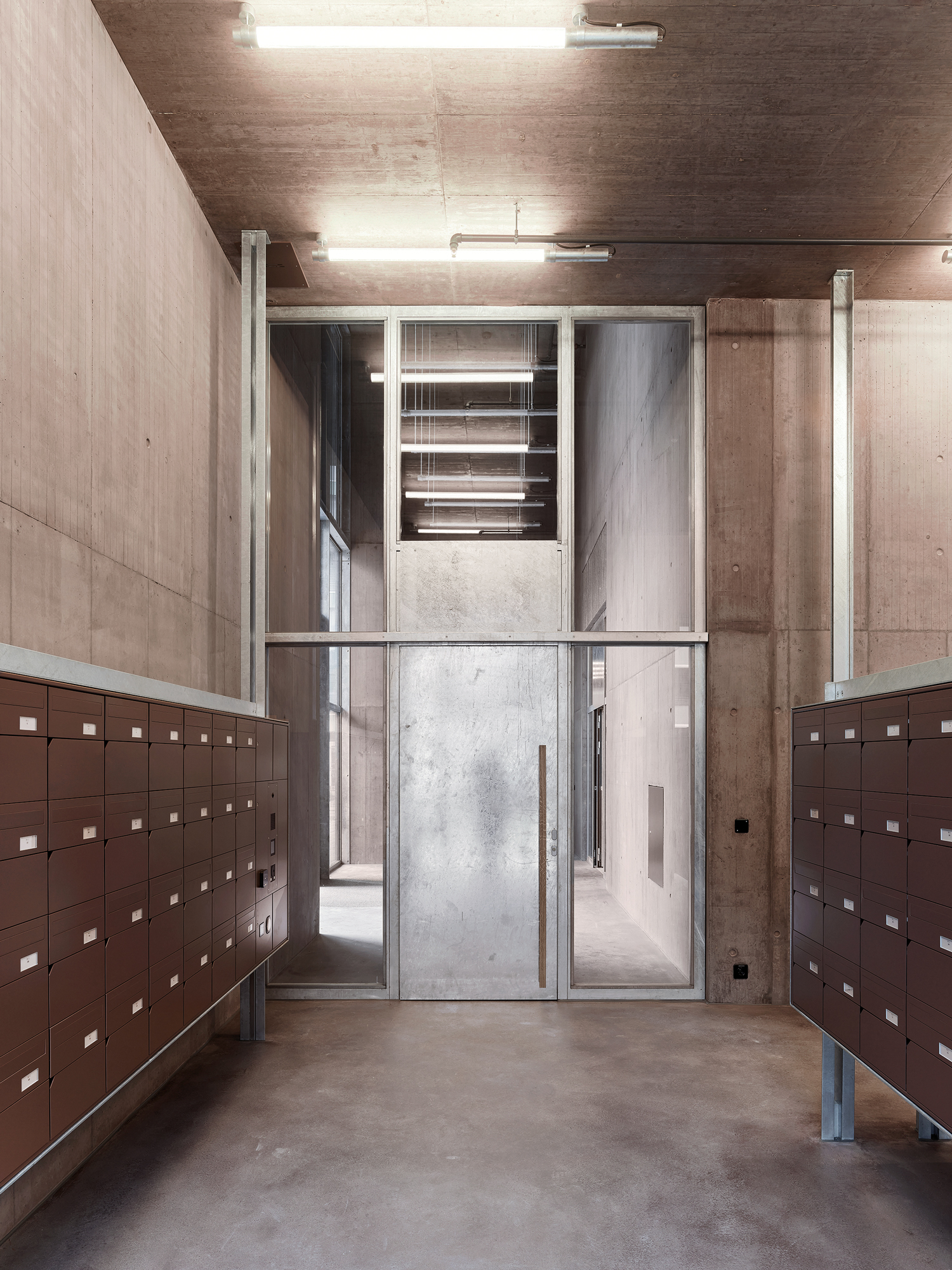 Red visibly exposed concrete walls define the entrance area and the ­enclosed ramp accessing the basement.