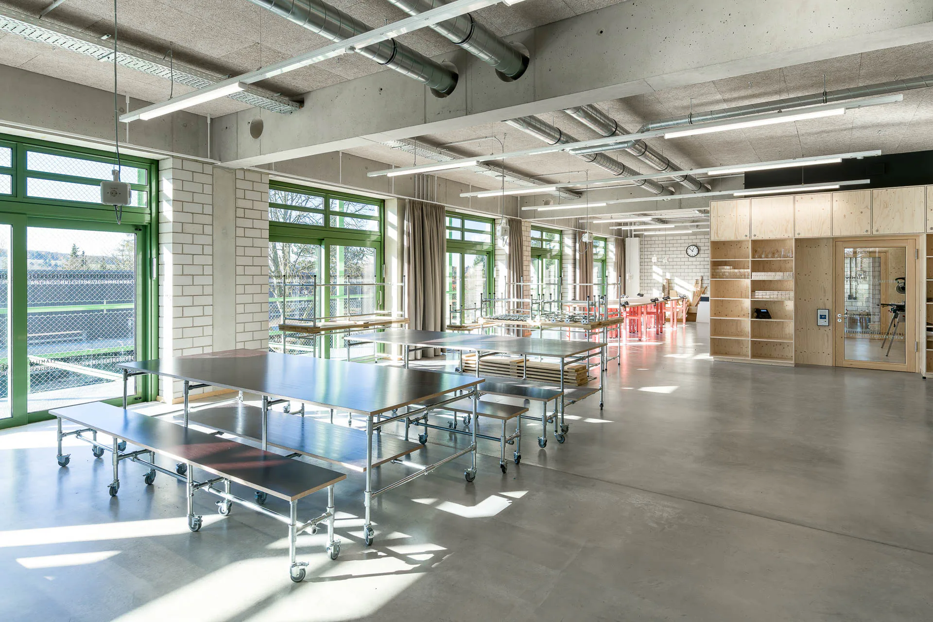 Lediglich einige eingestellte Holzkuben strukturieren den Lernbereich für Kunst und Werken. Die wenigen massiven Trennwände bestehen aus unverputztem Kalksandsteinmauerwerk.