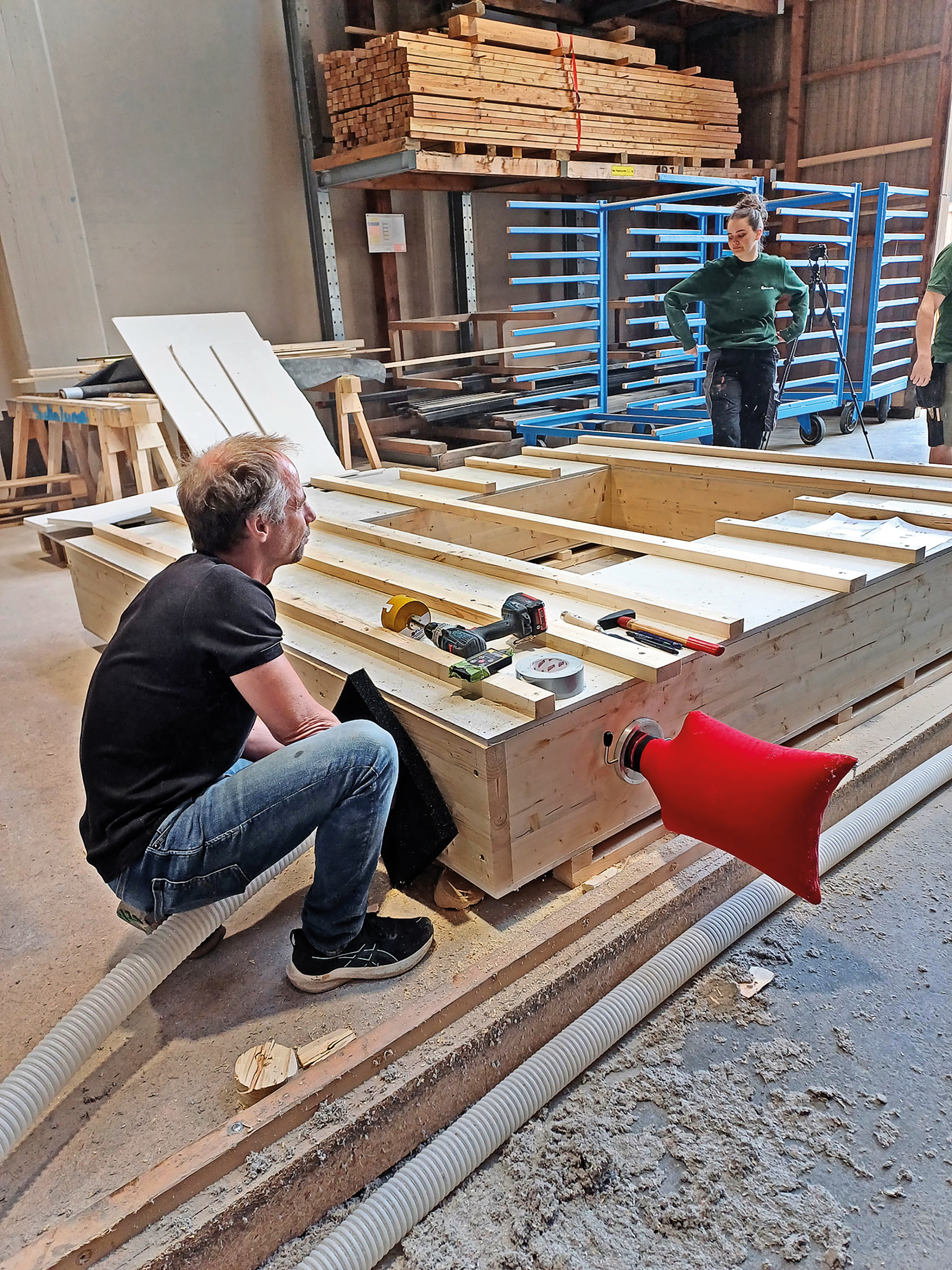The facade element is placed down horizontally and loose straw insulation blown into it for the rebuilding.