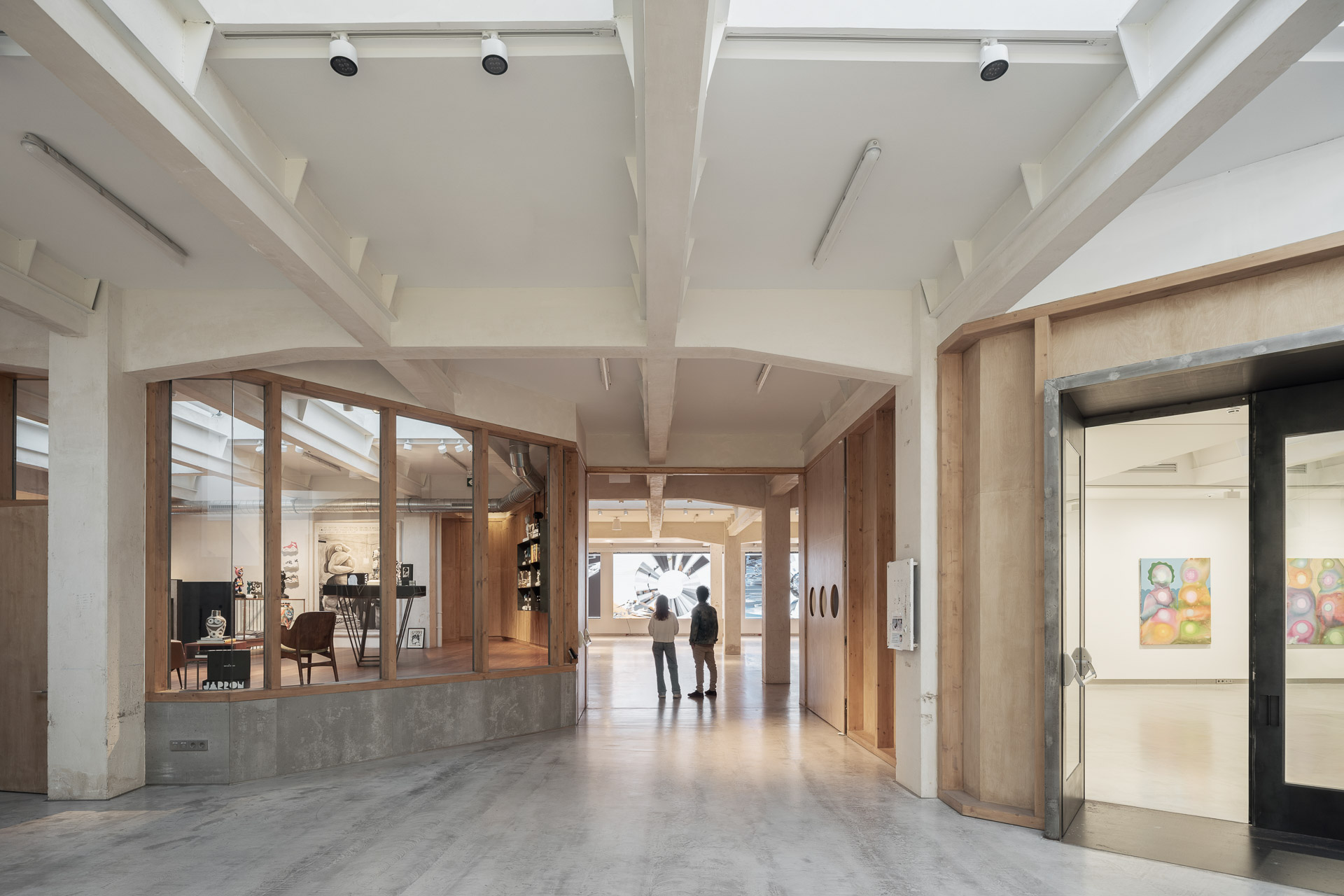 Einbauten aus Holz, Metall und Glas zonieren die ehemalige Halle der Druckerei im Erdgeschoss.