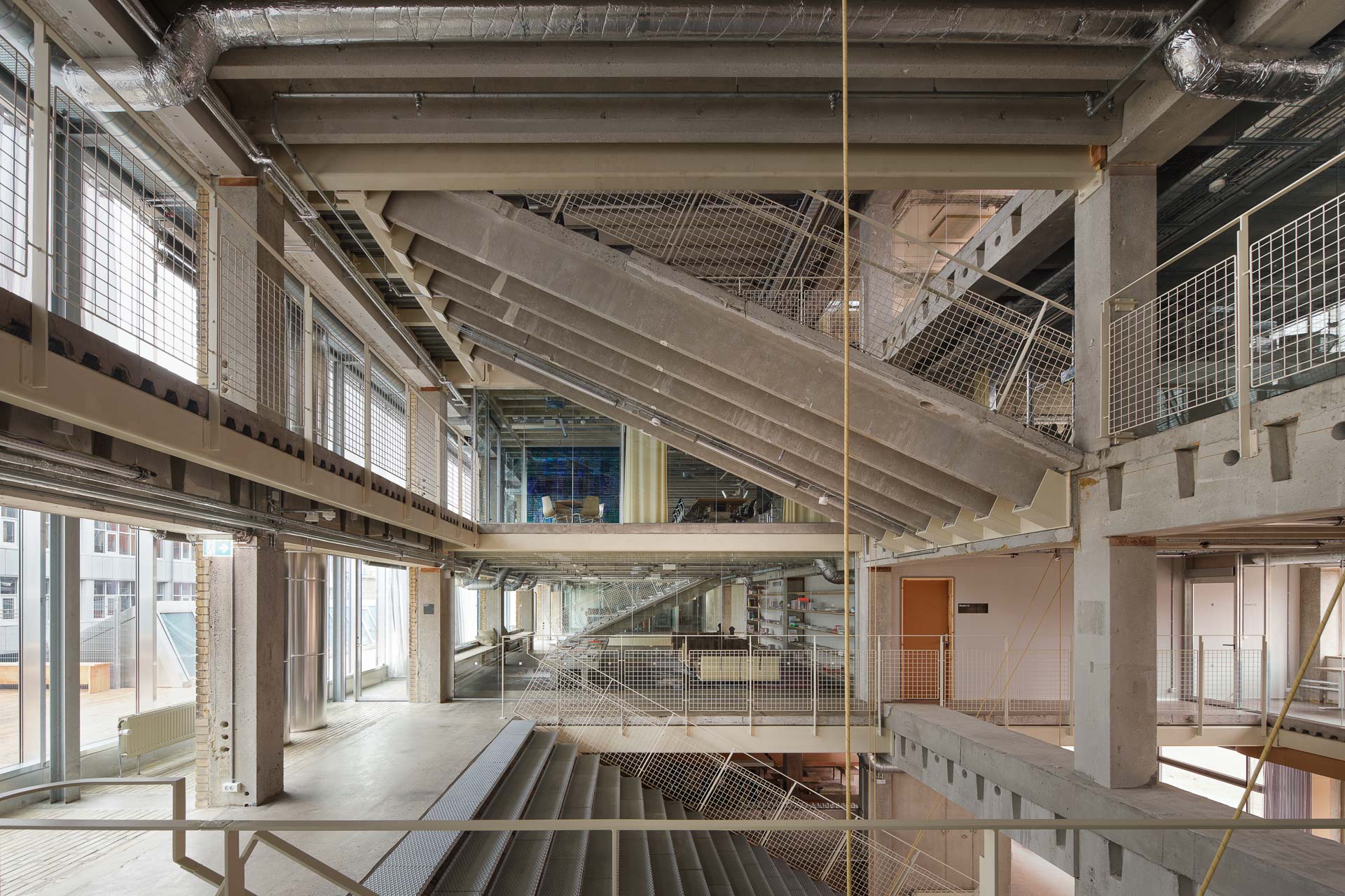 Mit zu Treppenläufen gekippten TT-Deckenplatten löst Pihlmann Architects die horizontale Gliederung auf und schafft ein völlig neues Raumerlebnis.