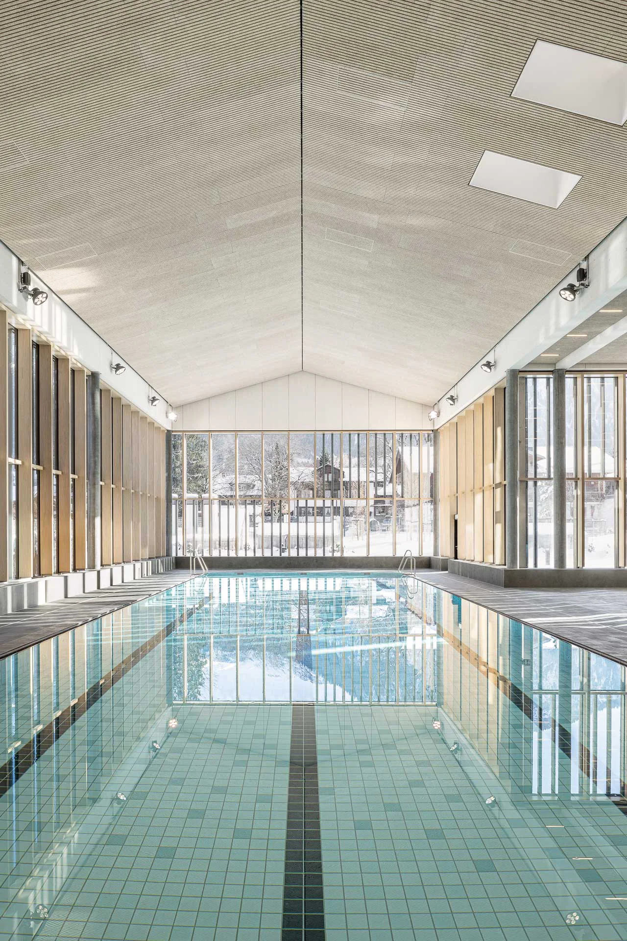 Rundmosaike der Serie Loop in Grün- und Blautönen verkleiden Liegeflächen und Beckenzonen der Therme Oberstdorf. Die Farbgestaltung orientiert sich an den Bergseen des Allgäus.