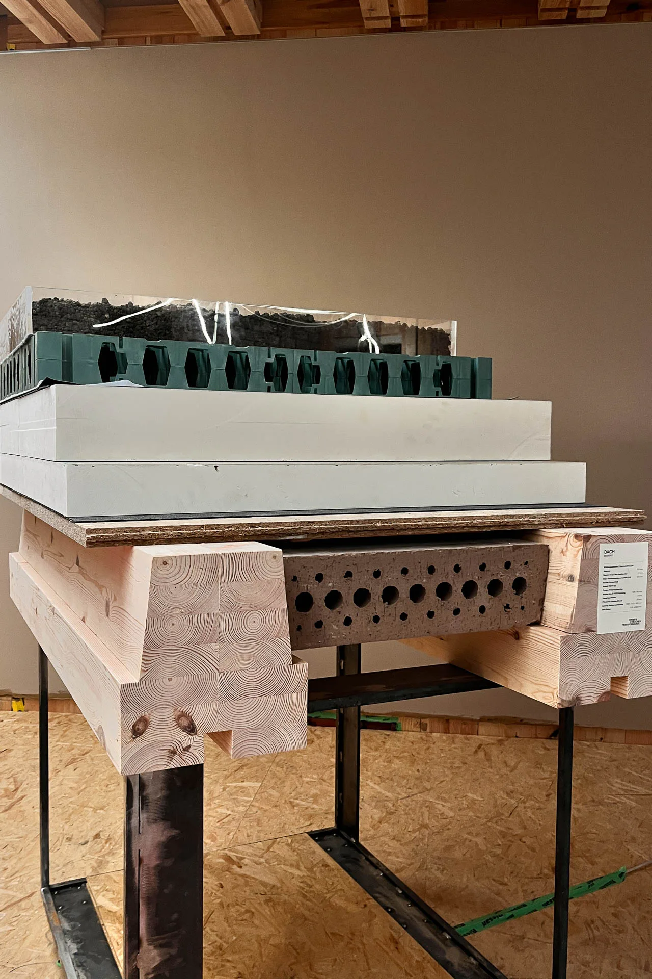 1:1-Mock-up des Dachaufbaus mit Holztragwerk, Lehmbauteilen, Dämmung und Abdichtung.