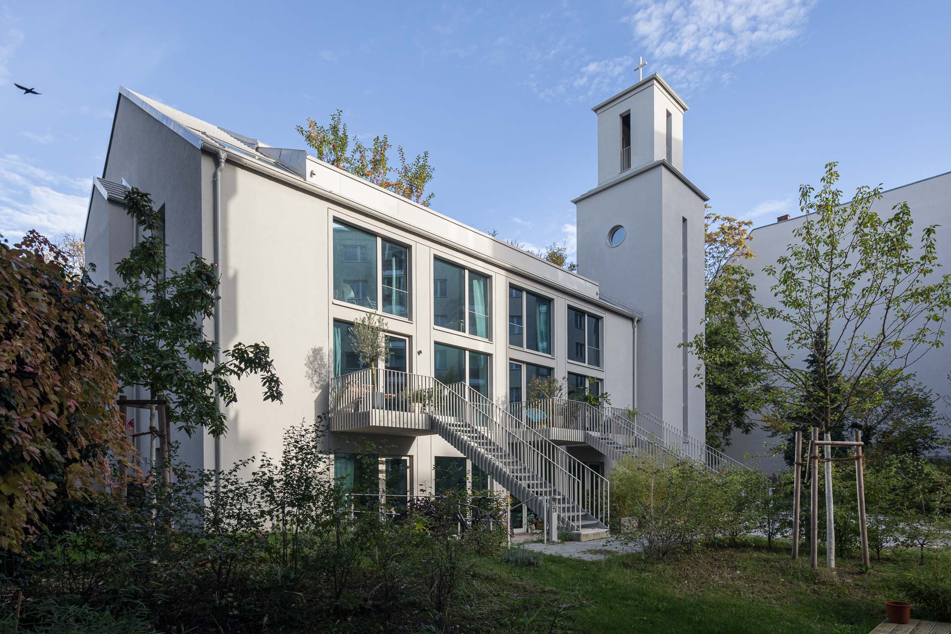 Gemeinschaftlich genutzte Grünflächen umgeben die transformierte Kirche.