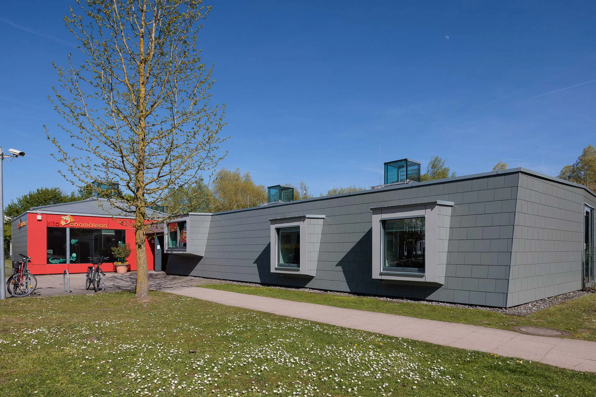 Die feine Struktur der Deckung unterstreicht die klare, geradlinige Architektursprache und bietet zugleich einen dauerhaft robusten Schutz vor Wind und Wetter.