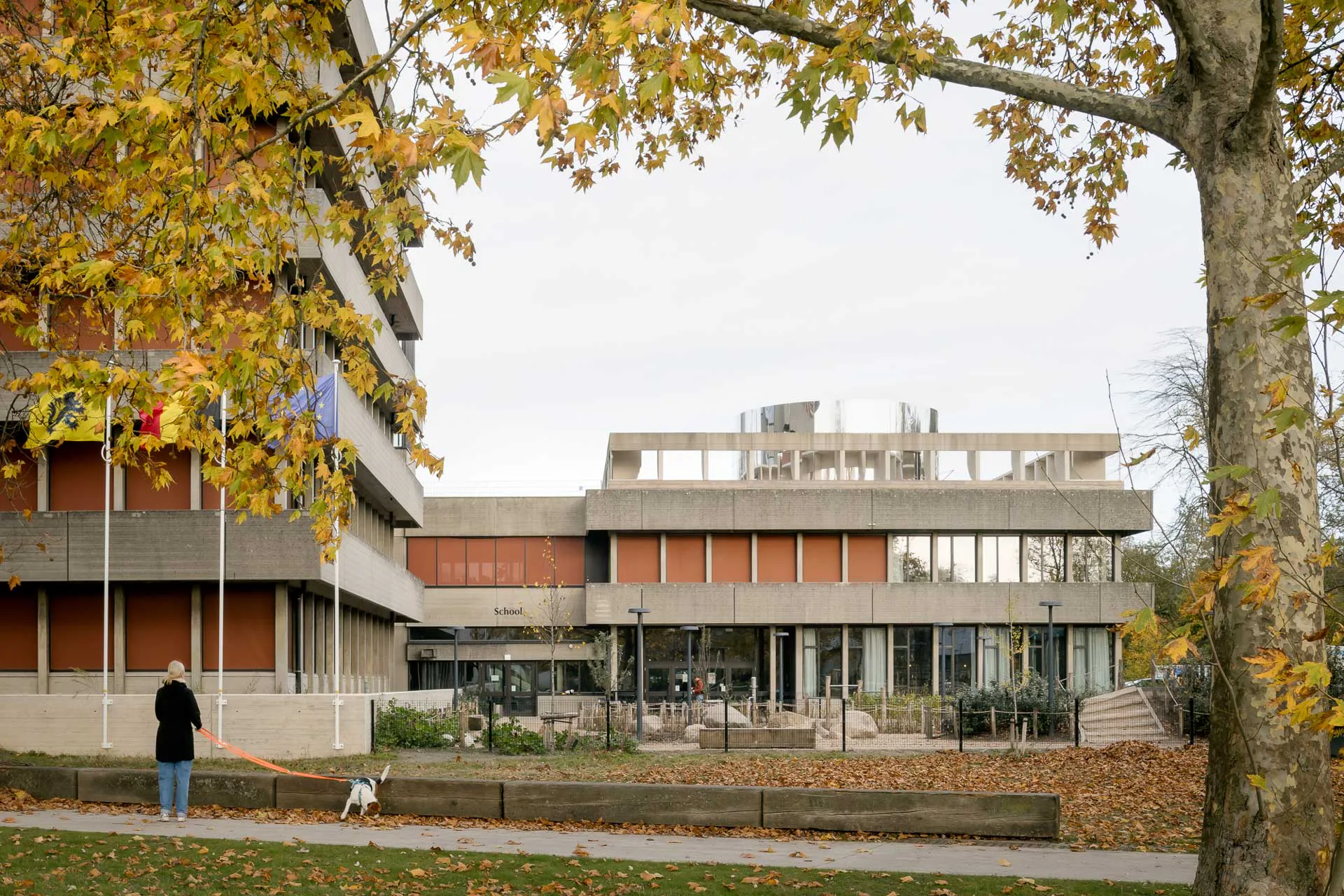 Der zur Schule umgenutzte Gebäudeteil erhielt einen Spielplatz auf dem Dach. In dem metallischen Zylinder sind Toiletten untergebracht.