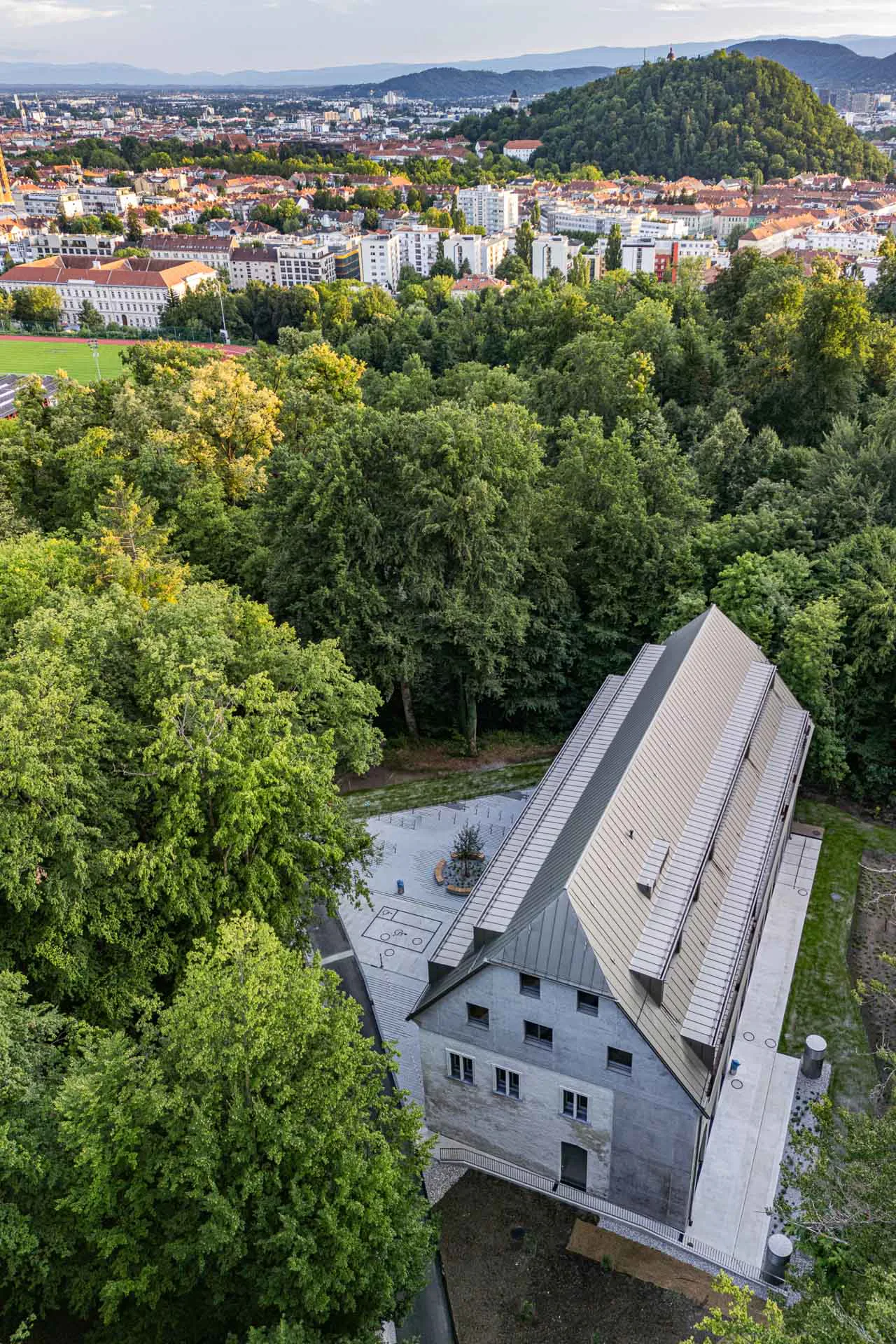 Die Stirnseite verrät, wie sich Alt- und Neubau verzahnen: Die verputzten Mauern des Bestandes treffen auf Erweiterung und Aufstockung in Leichtbeton.