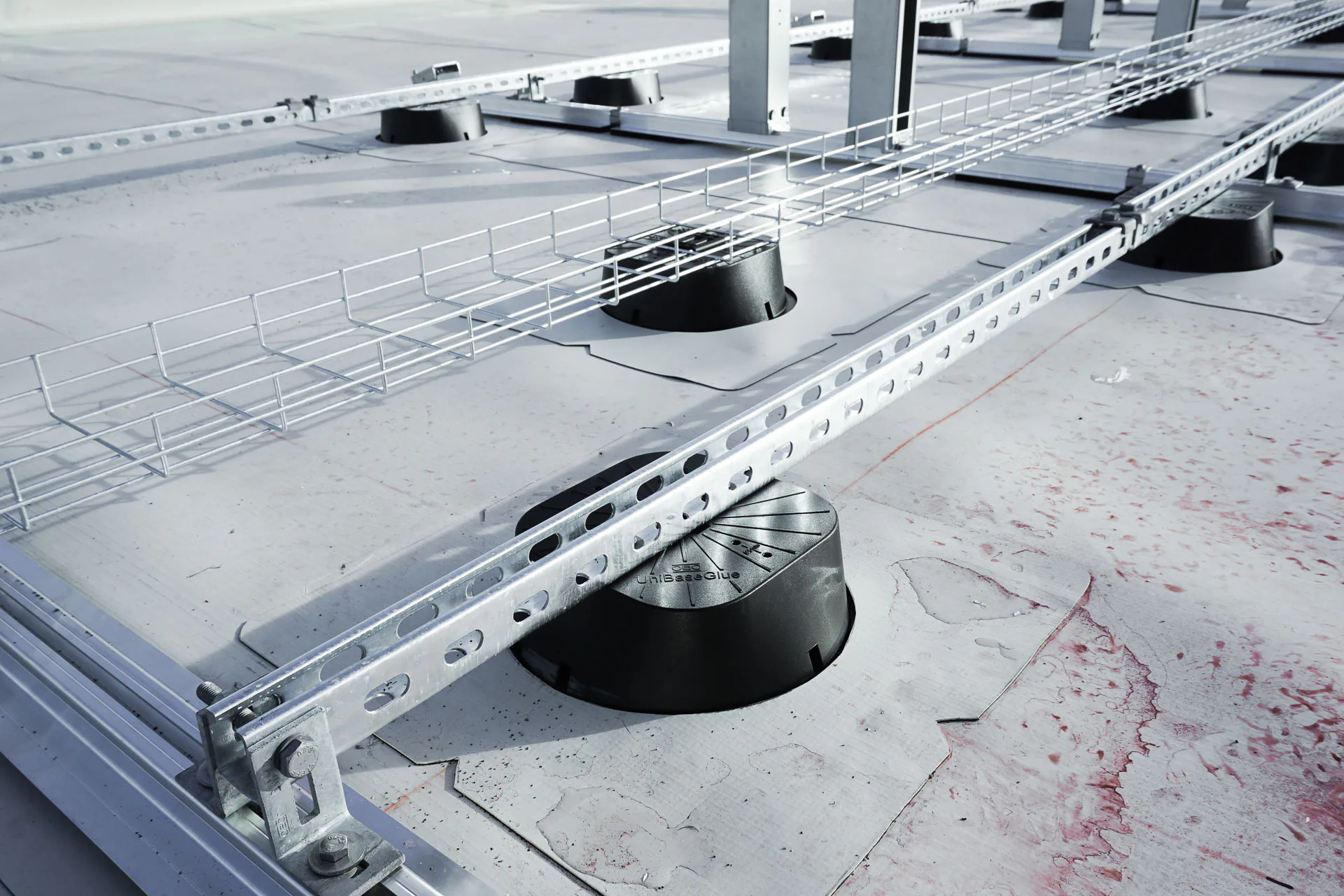 Ballastfreies Hybridsystem aus Magic PV Flat Basic, kombiniert mit Magic PV Flat Glue. Diese werden auf der Dachhaut ohne Dachdurchdringung verklebt