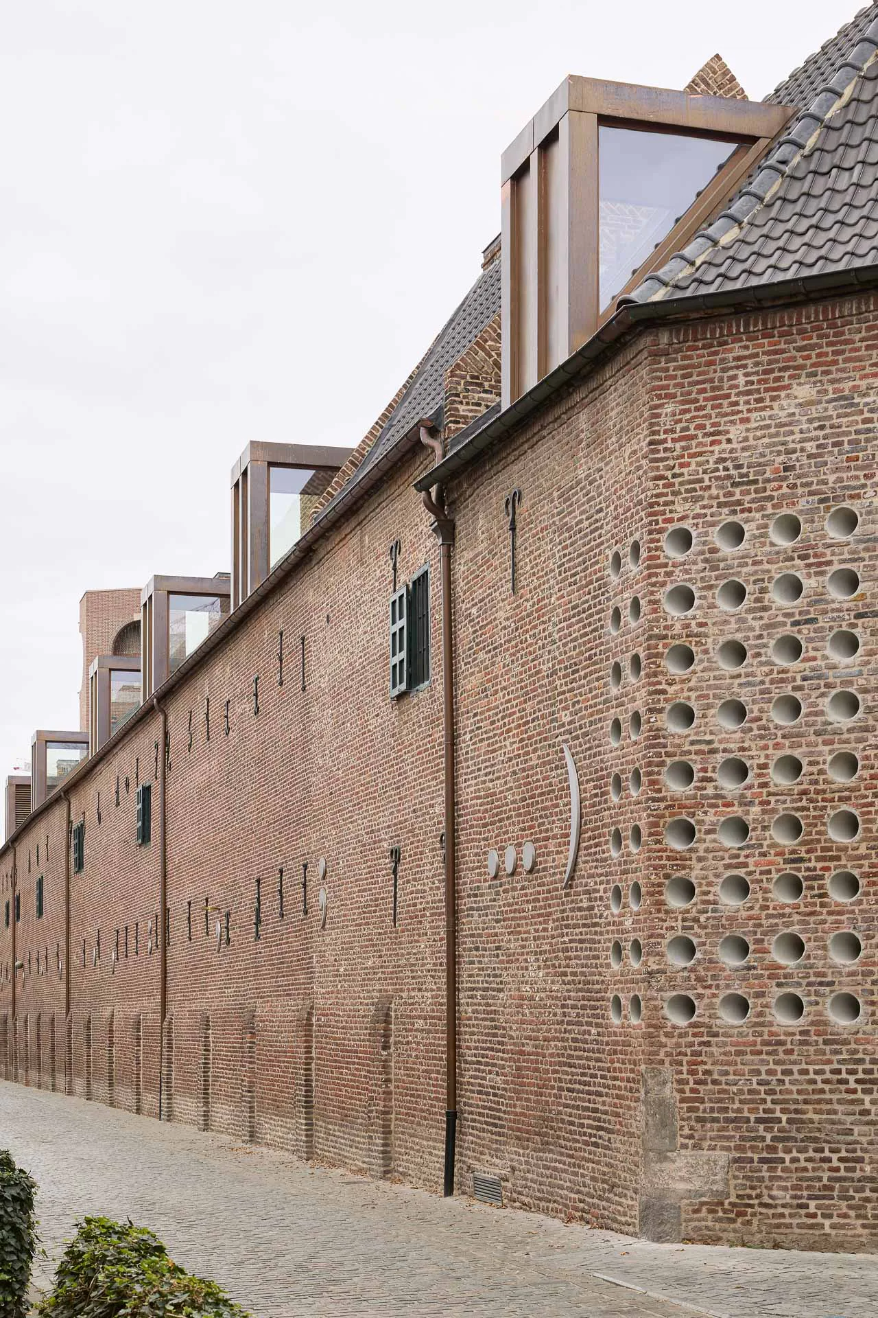 Gegen den Rest der Stadt schirmen sich die Wohnhäuser der Beginen mit nahezu fensterlosen Fassaden ab. Dieses Bild blieb auch bei dem Umbau zur Architekturfakultät erhalten.