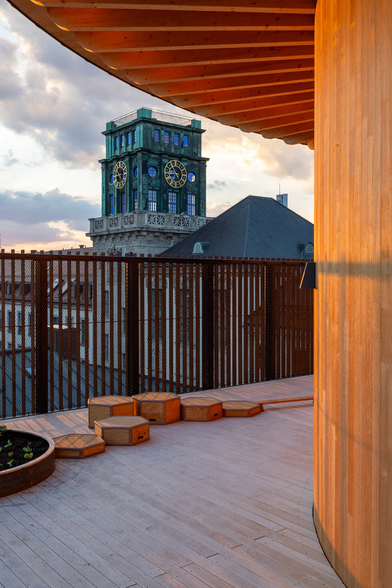 Auf der Dachterrasse spielen die Kinder unter freiem Himmel. Ein breiter Dachüberstand rings um den Holzkern spendet an heißen Tagen Schatten.