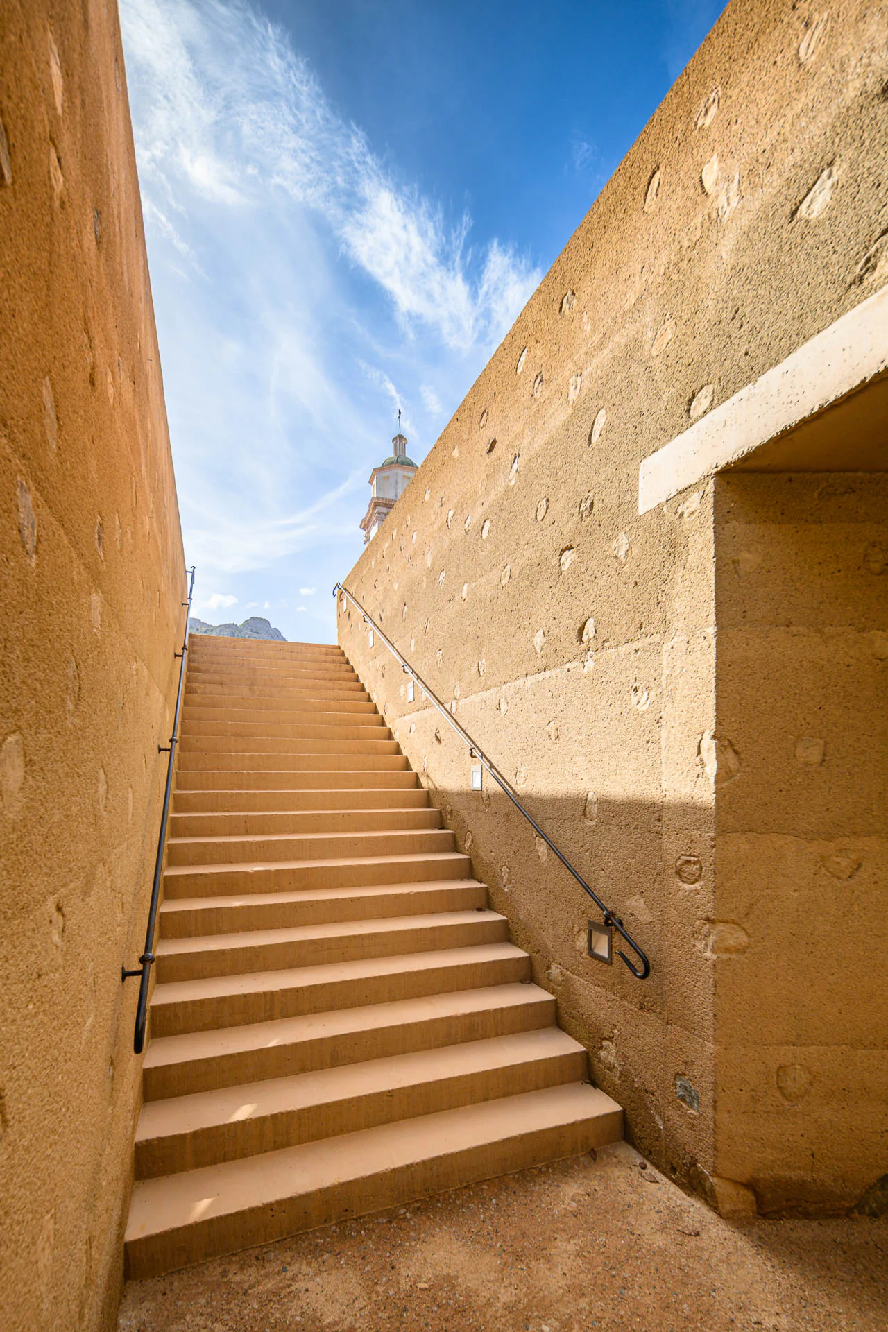 Eine Treppe führt von der höher gelegenen Straße hinunter zum Gemeindesaal.
