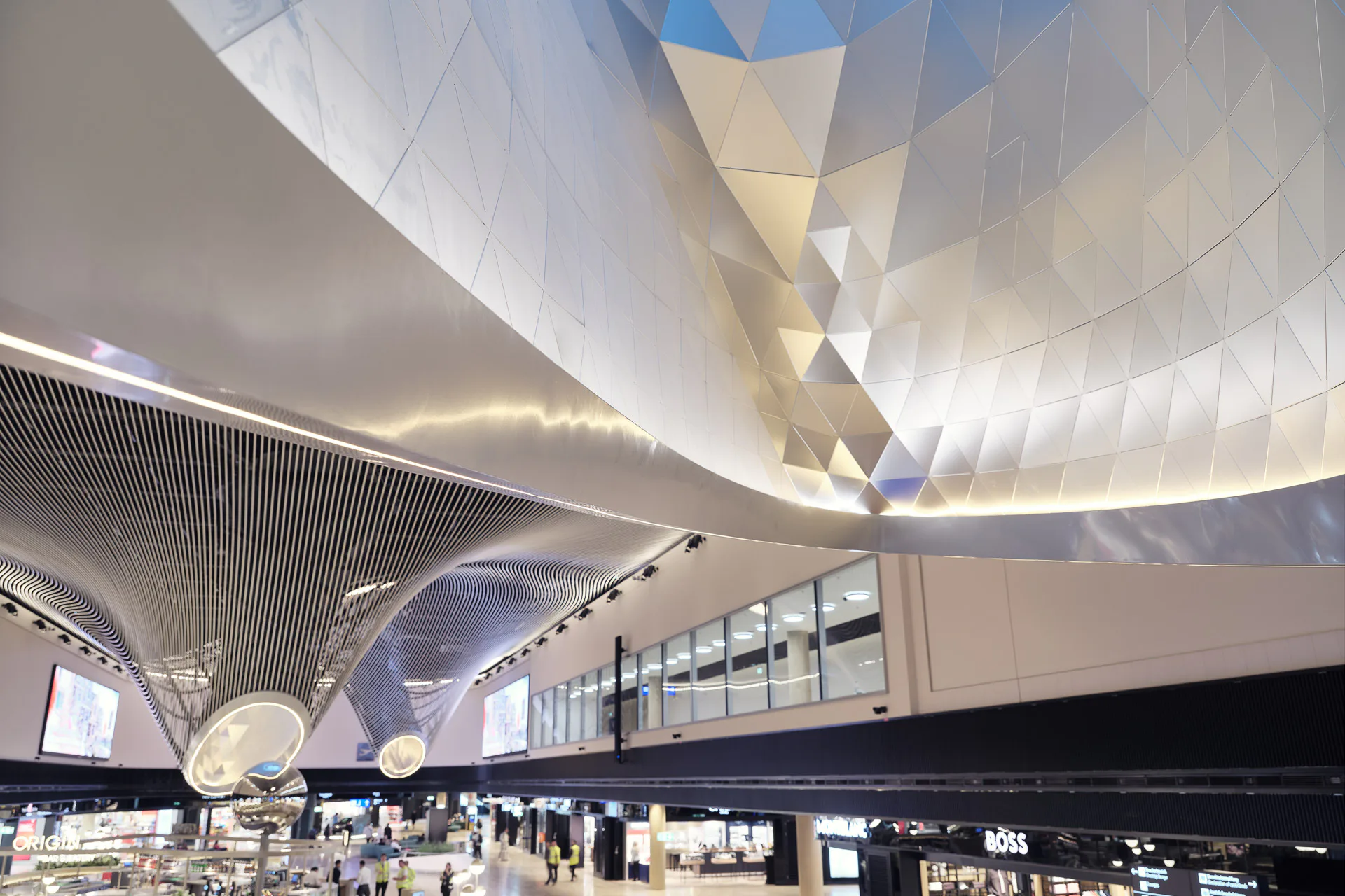 Die Innenseiten der frei geformten Oberlichttrichter sind mit mattiertem Aluminium ausgekleidet. So wird das Tageslicht tief in die Halle blendungsfrei reflektiert.