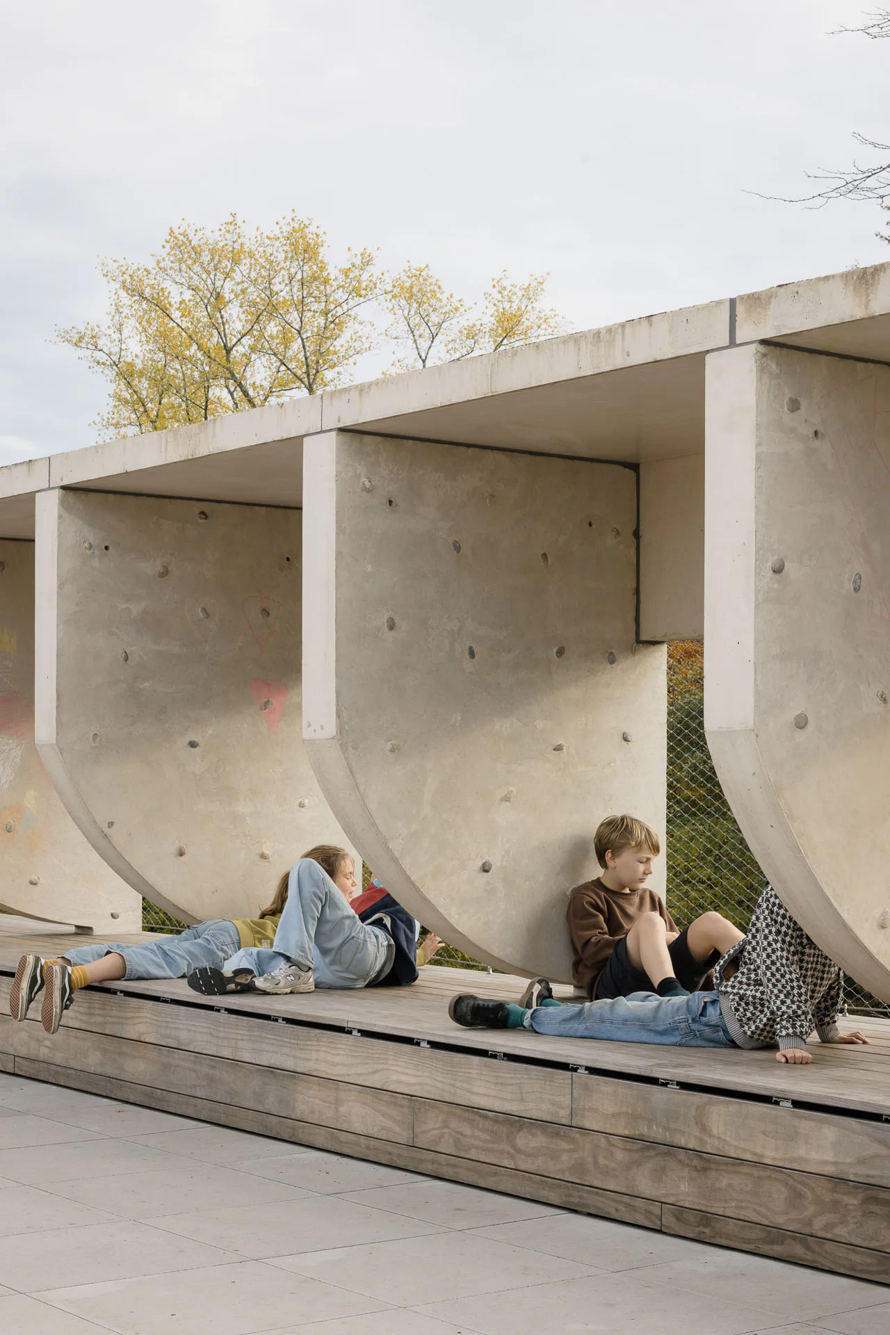 Ein Brise-Soleil aus kreisförmig geschnittenen Betonfertigteilen schließt den Dachspielplatz nach außen ab.