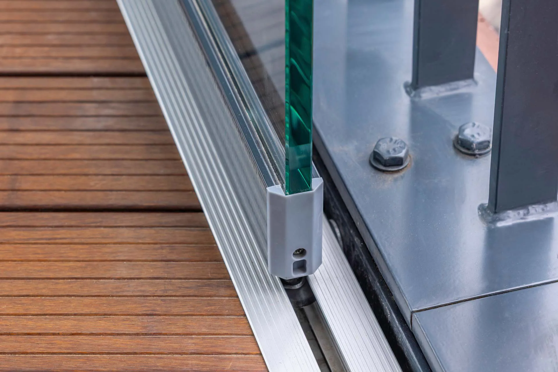 Detail der barrierefreien Bodenschiene des Systems Proline T Mega von Solarlux mit 15 mm starker ESG‑Verglasung und polierten Glaskanten.