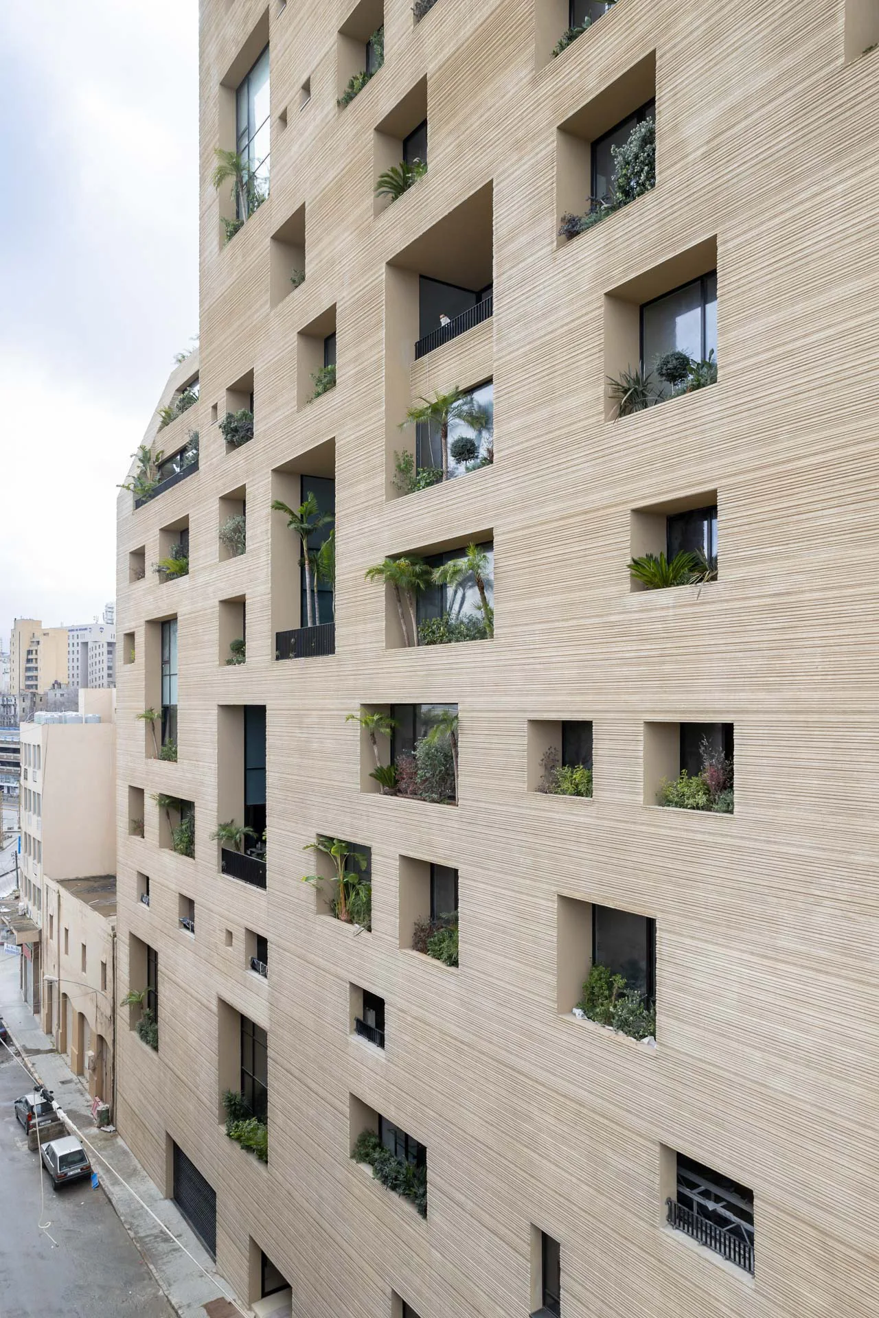 Stone Garden in Beirut (2020). Die Fassade ist von unterschiedlich großen Öffnungen durchbrochen, die zu grünen Balkonen werden.