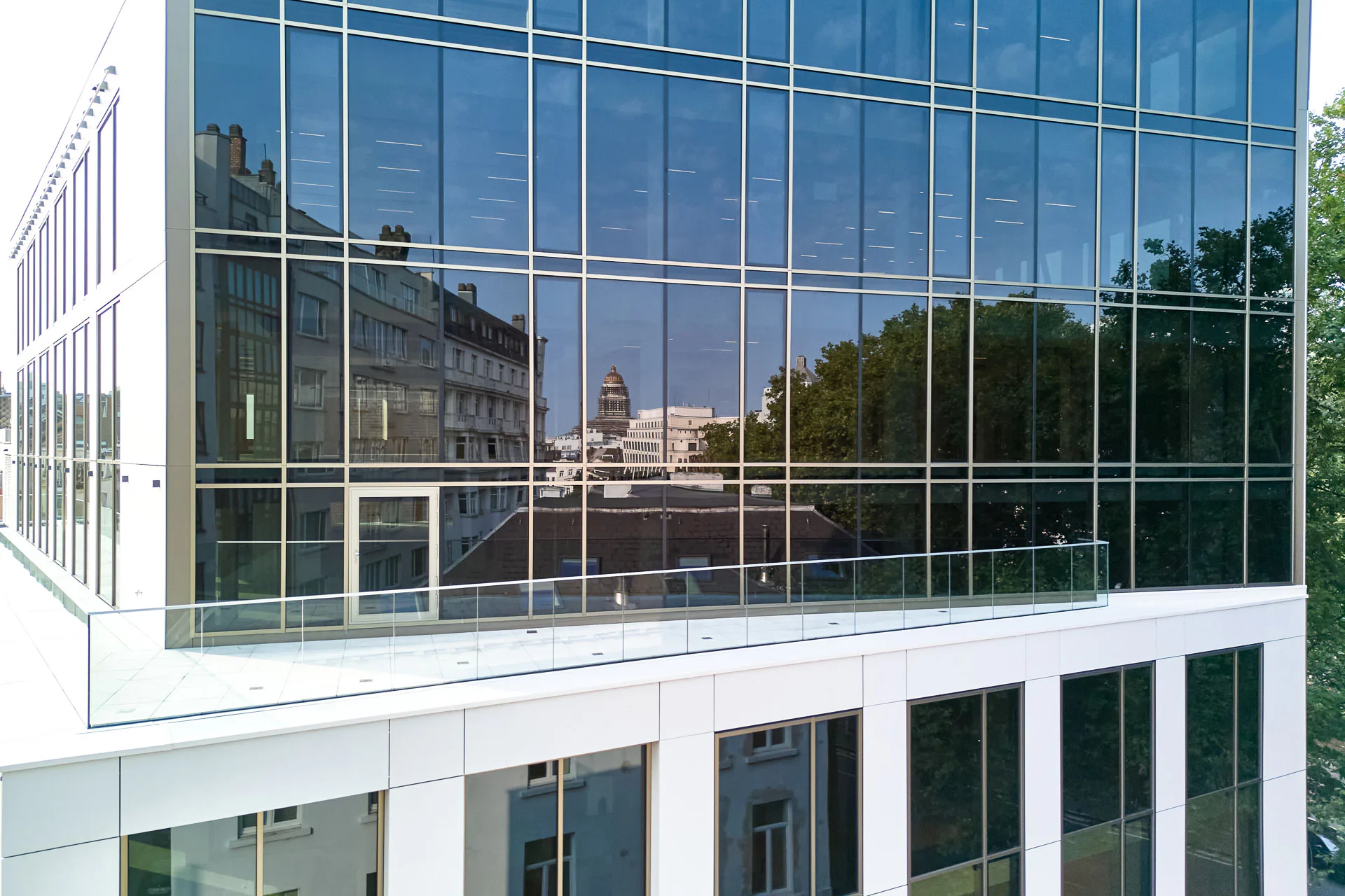 Große Glasflächen öffnen das Gebäude zur Stadt hin. Die Dekton-Paneele der vorgehängten hinterlüfteten Fassade sind von außen unsichtbar mit Hinterschnittankern fixiert.